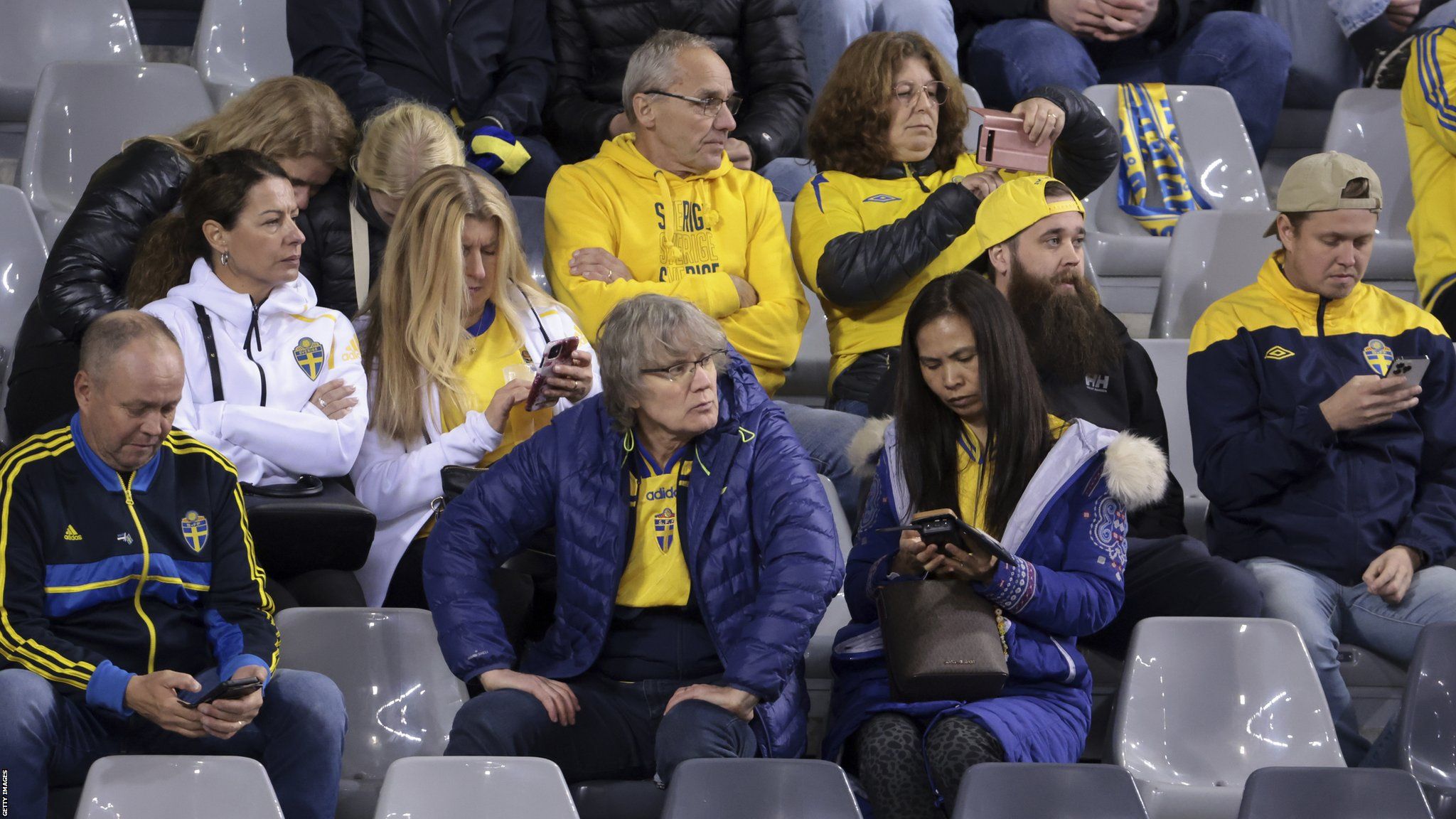 Fans of Sweden on their phones to get information on the terrorist attack in Brussels during the Euro 2024 qualifier match between Belgium and Sweden at King Baudouin Stadium in Brussels.