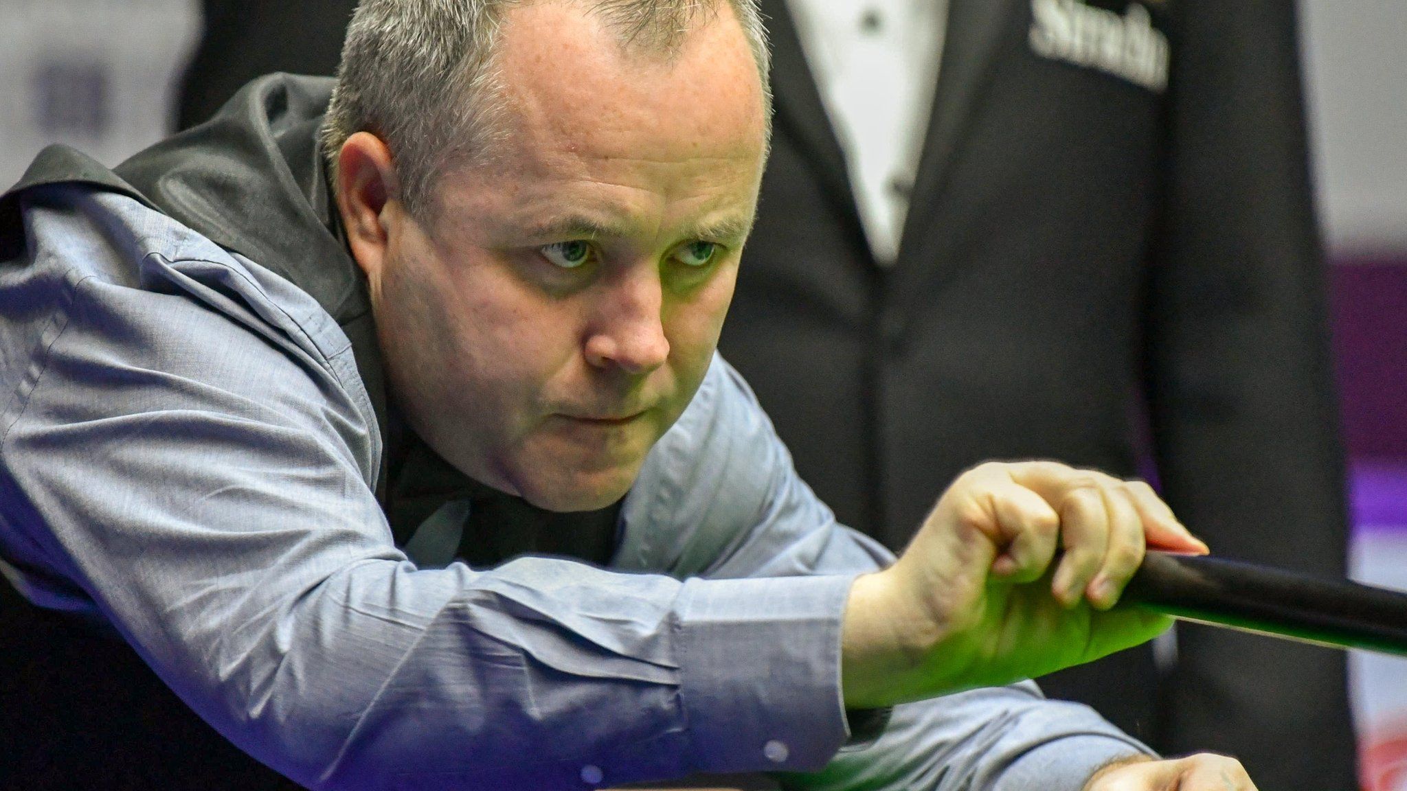 John Higgins plays a shot with the rest in China
