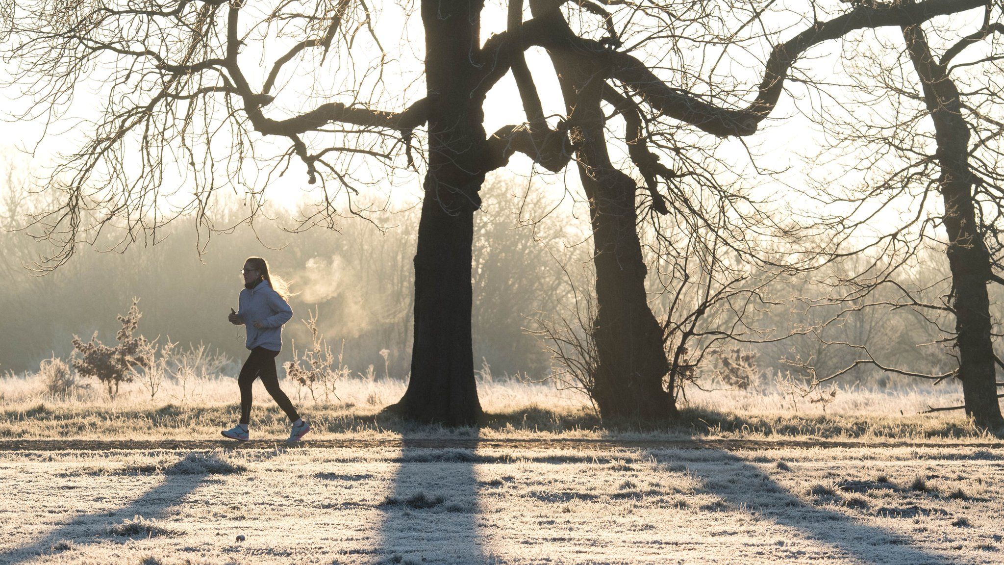 A woman runs in Wanstead Park, London on Thursday morning