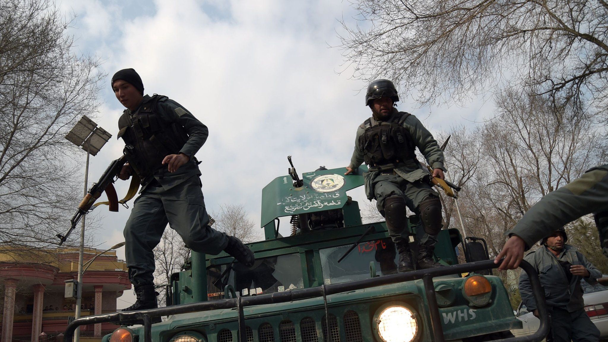 This file photo taken on 8 March 2017 shows Afghan policemen leaping from a vehicle as they arrive outside a military hospital during an attack in Kabul
