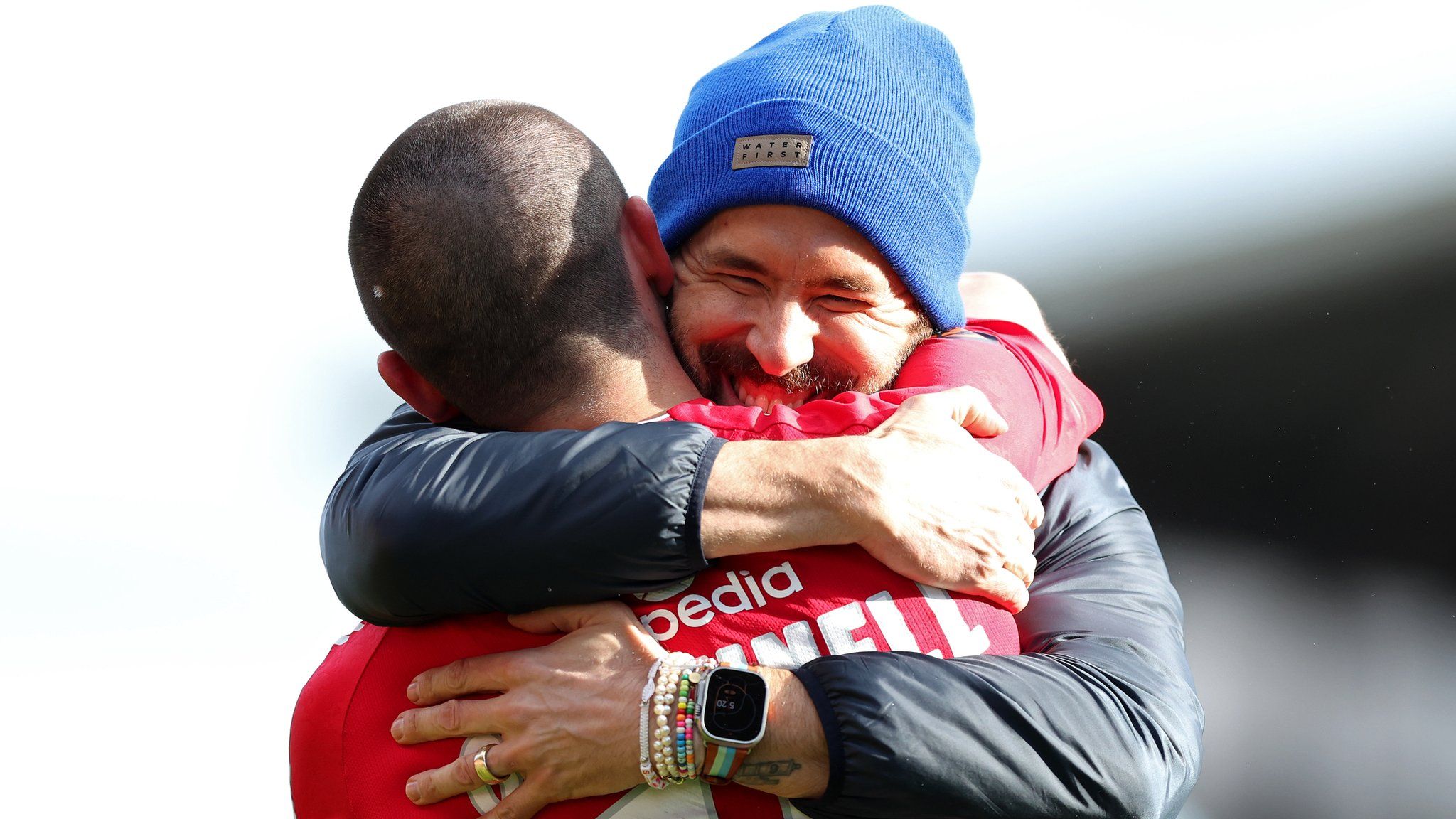 Eoghan O'Connell is hugged by Wrexham co-owner Ryan Reynolds