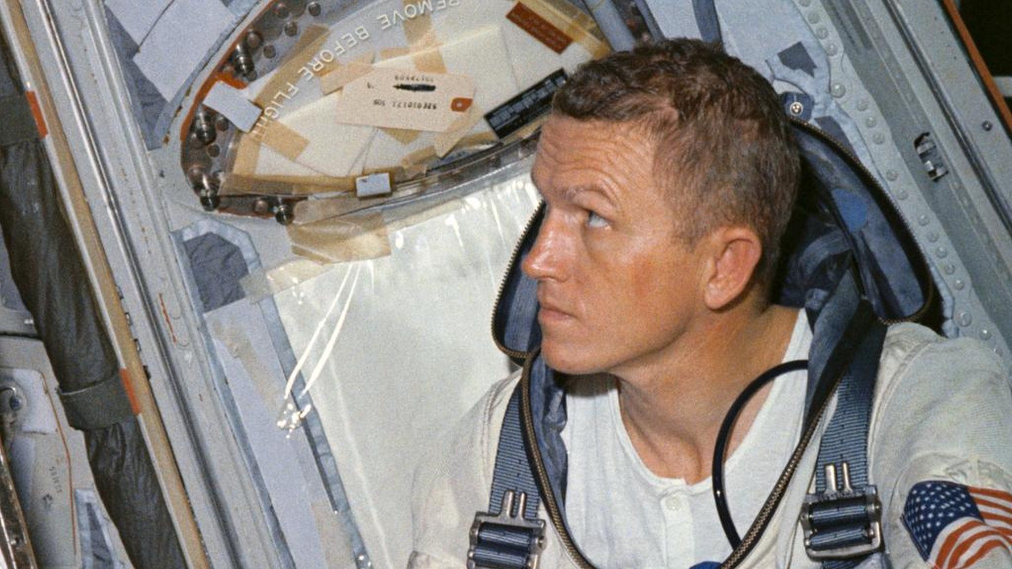 Frank Borman in spacecraft with a white tshirt