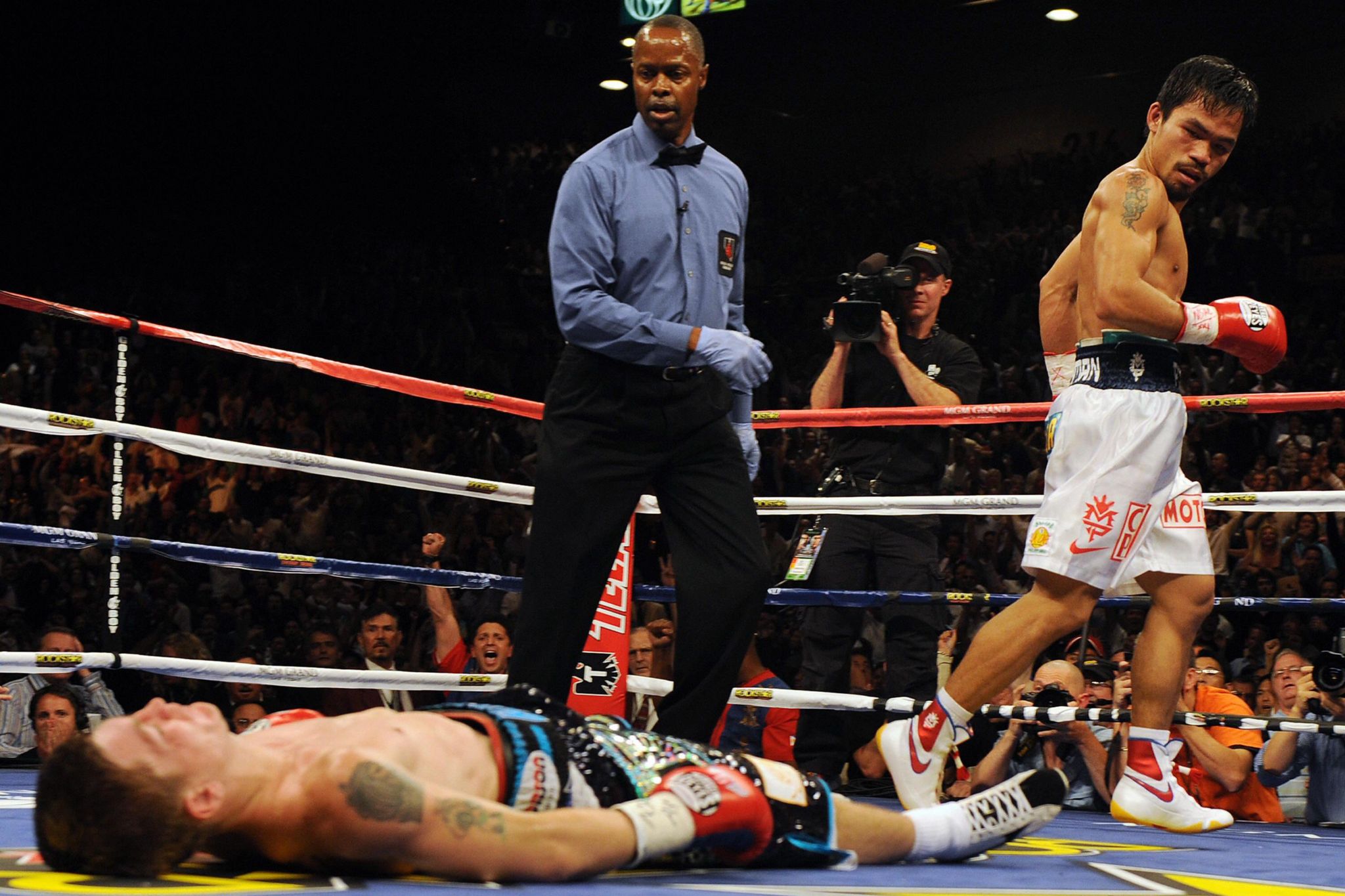 Ricky Hatton lies on the canvas watched over by the referee and Manny Pacquiao