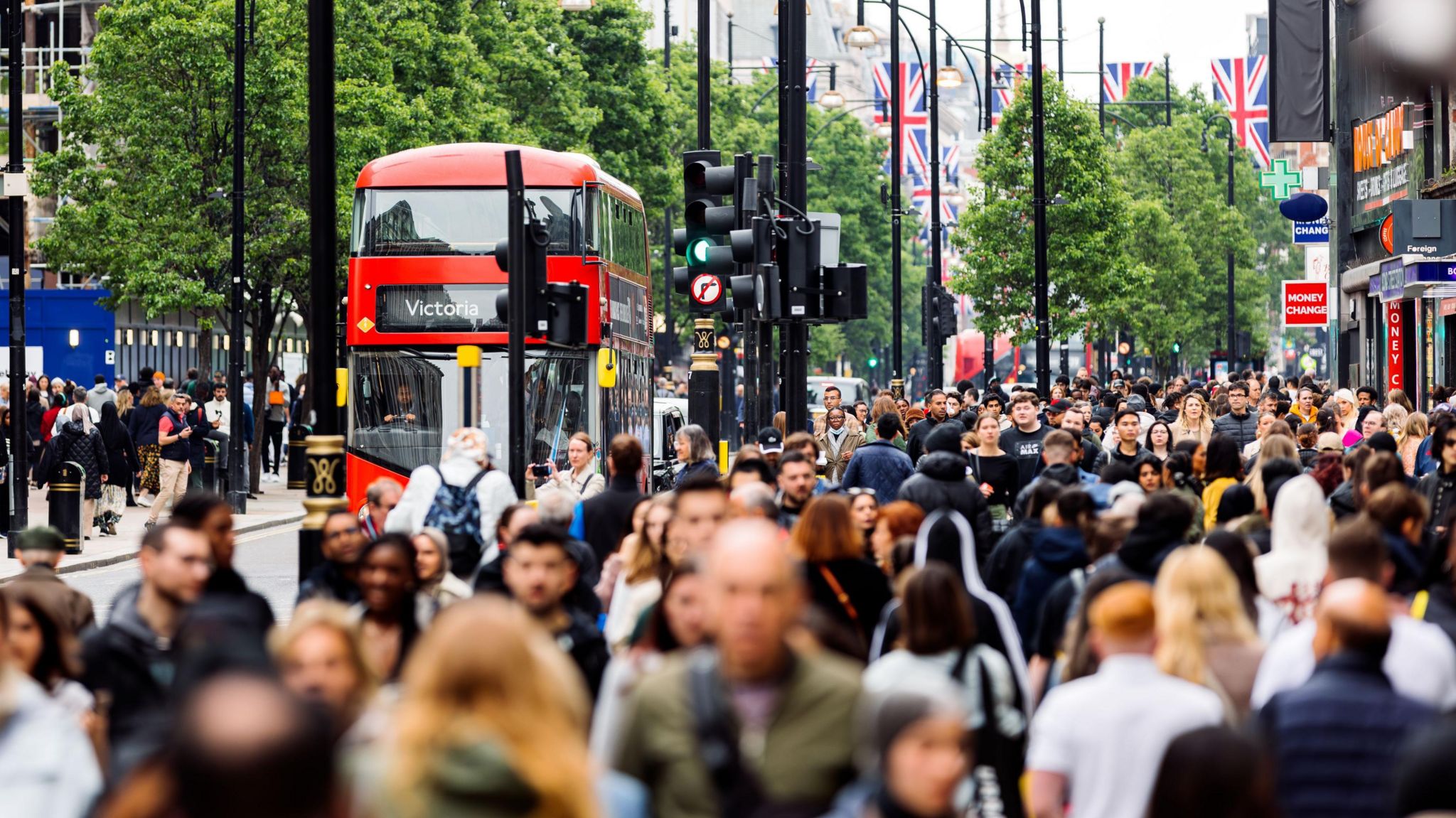 Busy street scene with lots of pedestrians and buses 