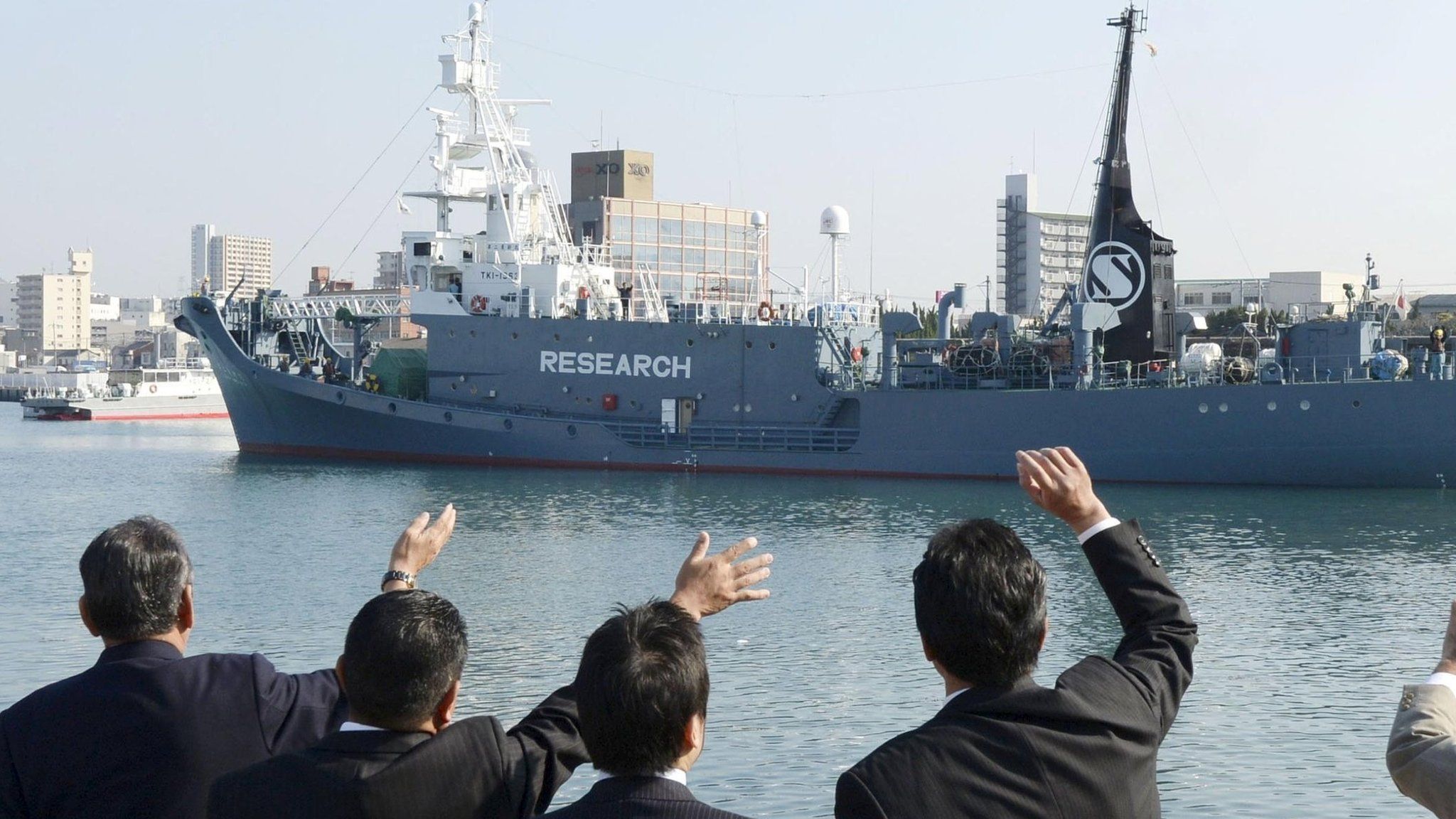 Officials wave as Japanese whaling vessel Yushin Maru No.2 leaves for the Antarctic Ocean