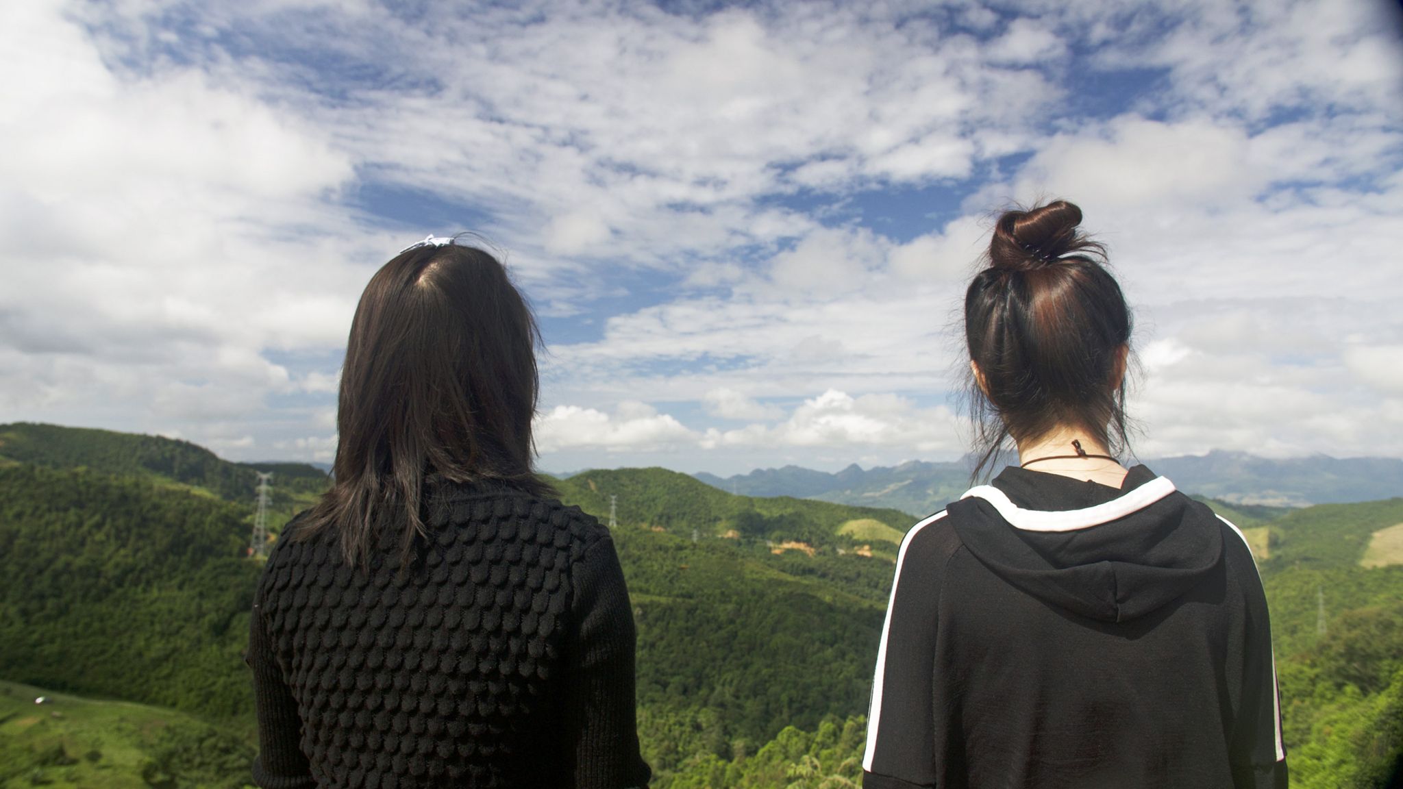 Now safely over the border Mira (L) and Jiyun (R) look out over a mountain range back towards China