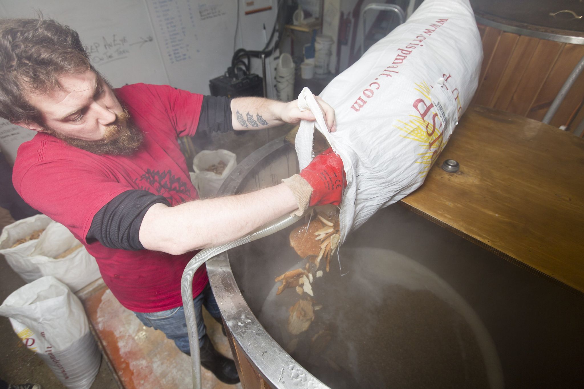 A worker pours bread into a barrel