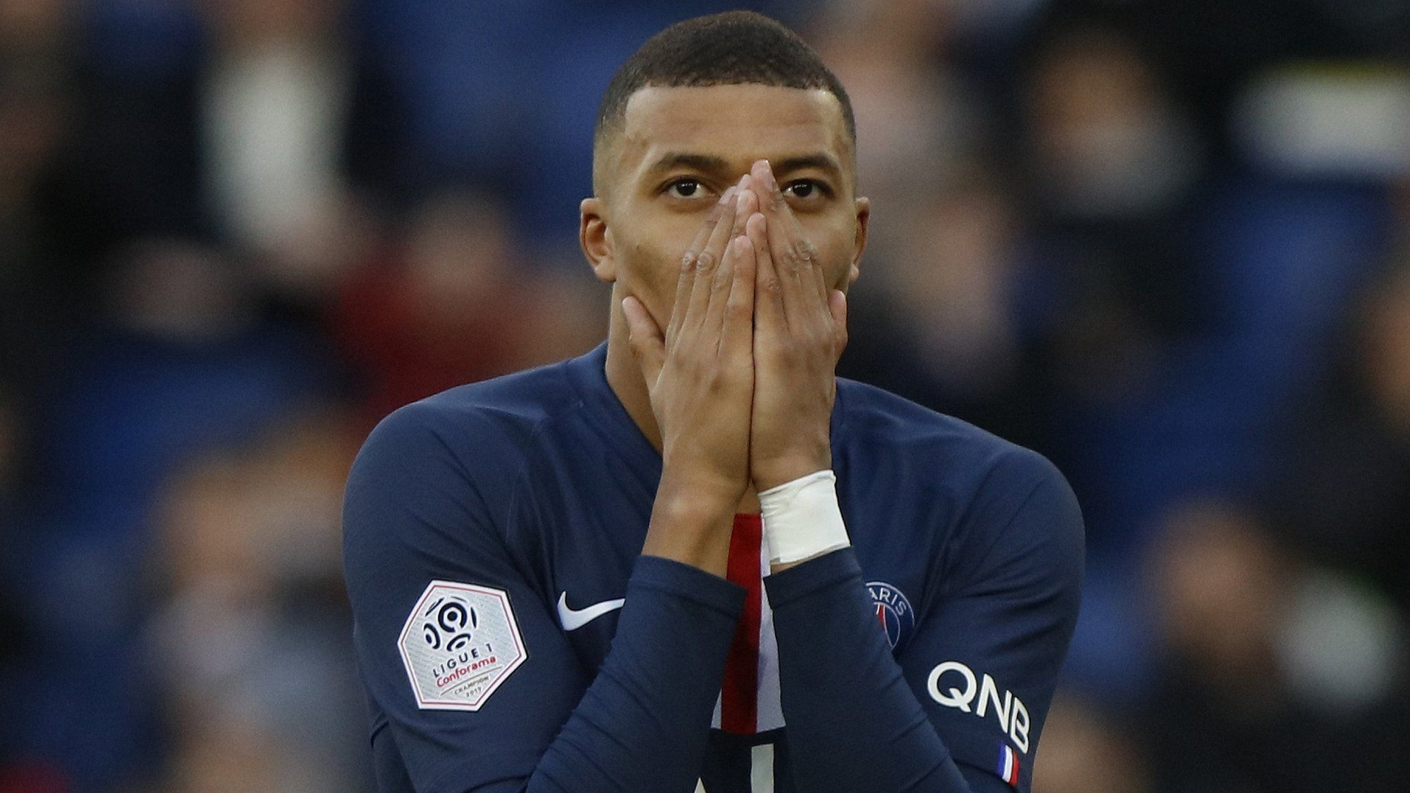 PSG forward Kylian Mbappe puts his hands over his mouth