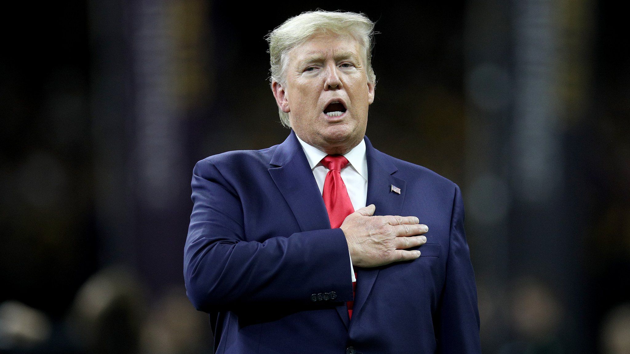US President Donald Trump stands for the national anthem at a football game in New Orleans, Louisiana, on 13 January 2013