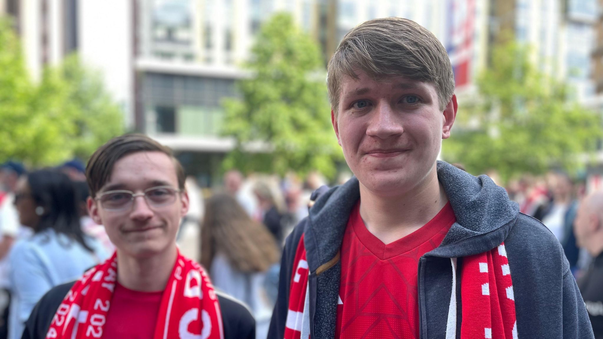 Two people stood next to one another wearing Crawley Town's red scarves