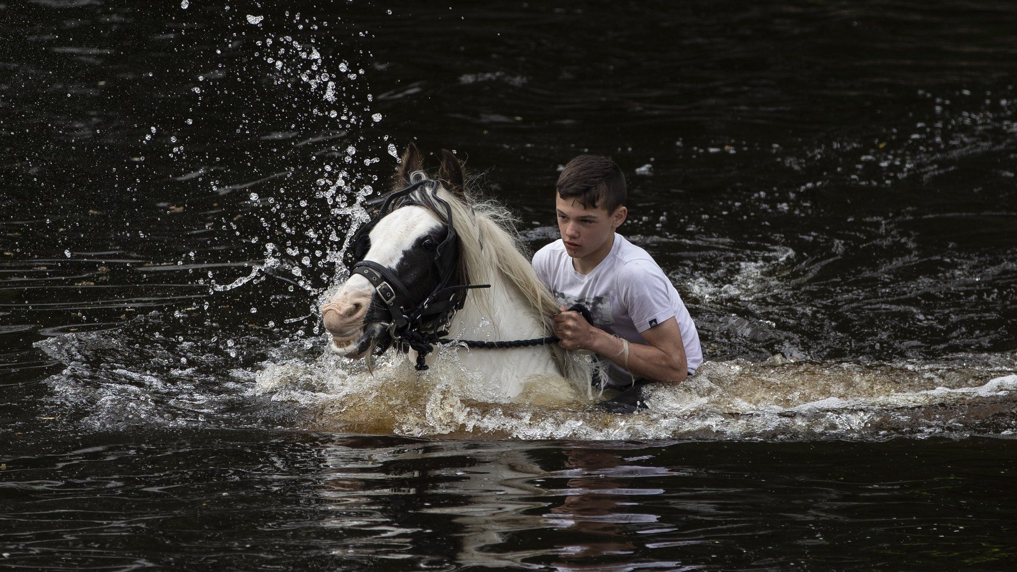 A boy rides his horse in the River Eden during the annual Appleby Horse Fair
