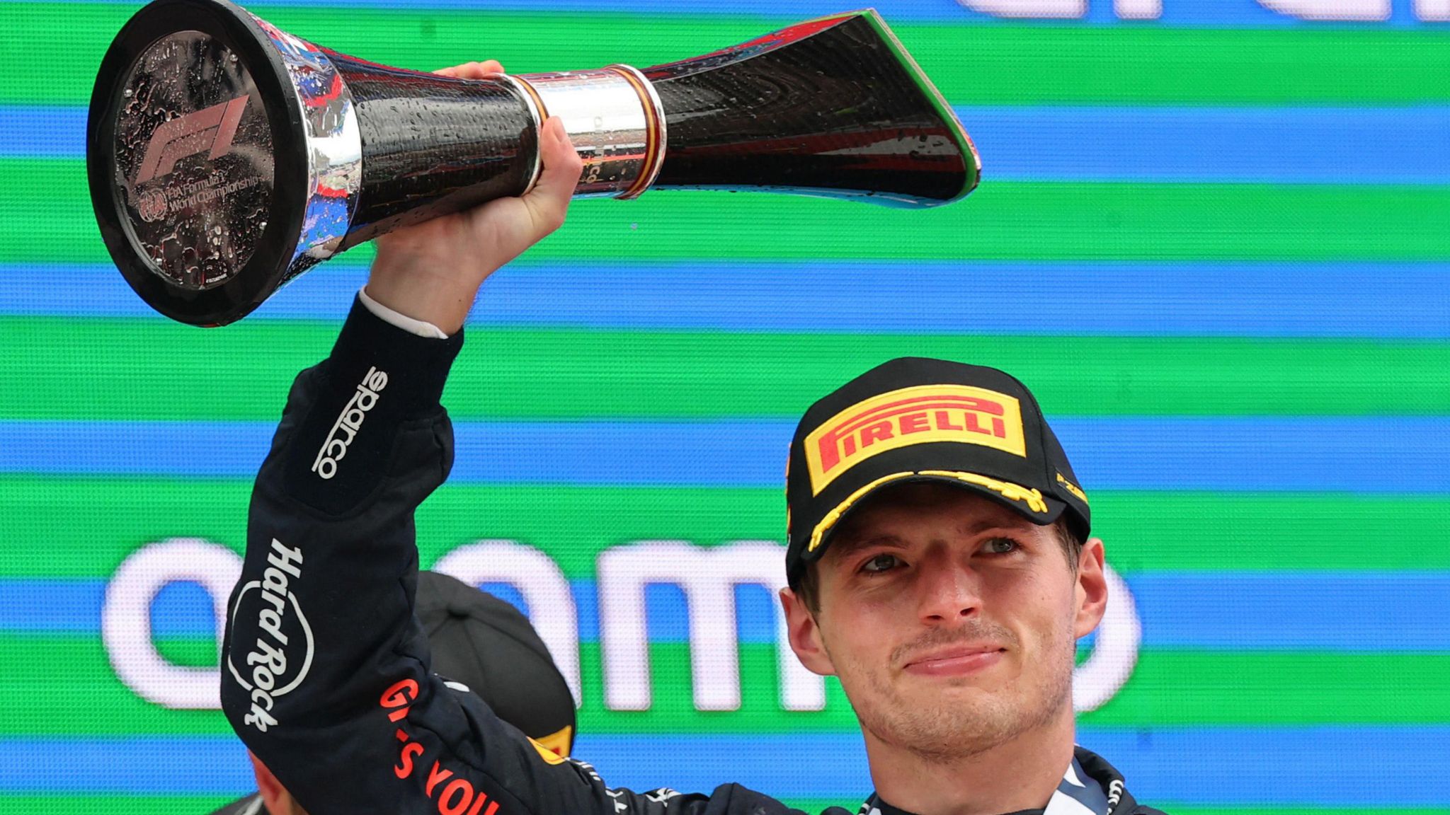 Max Verstappen holds the winner's trophy above his head after winning the Spanish Grand Prix