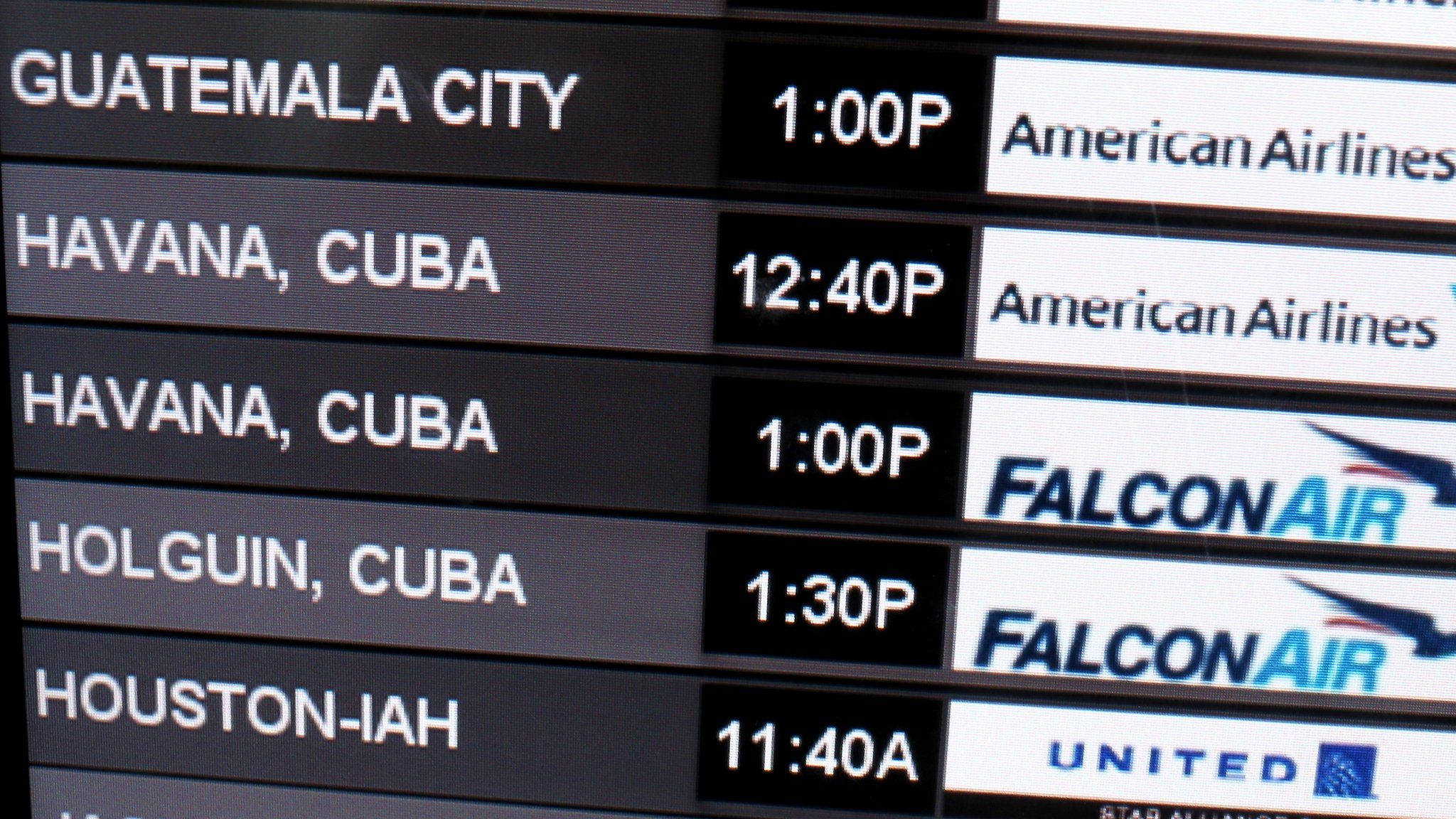 An airport arrivals and departures board that includes flights to Cuba