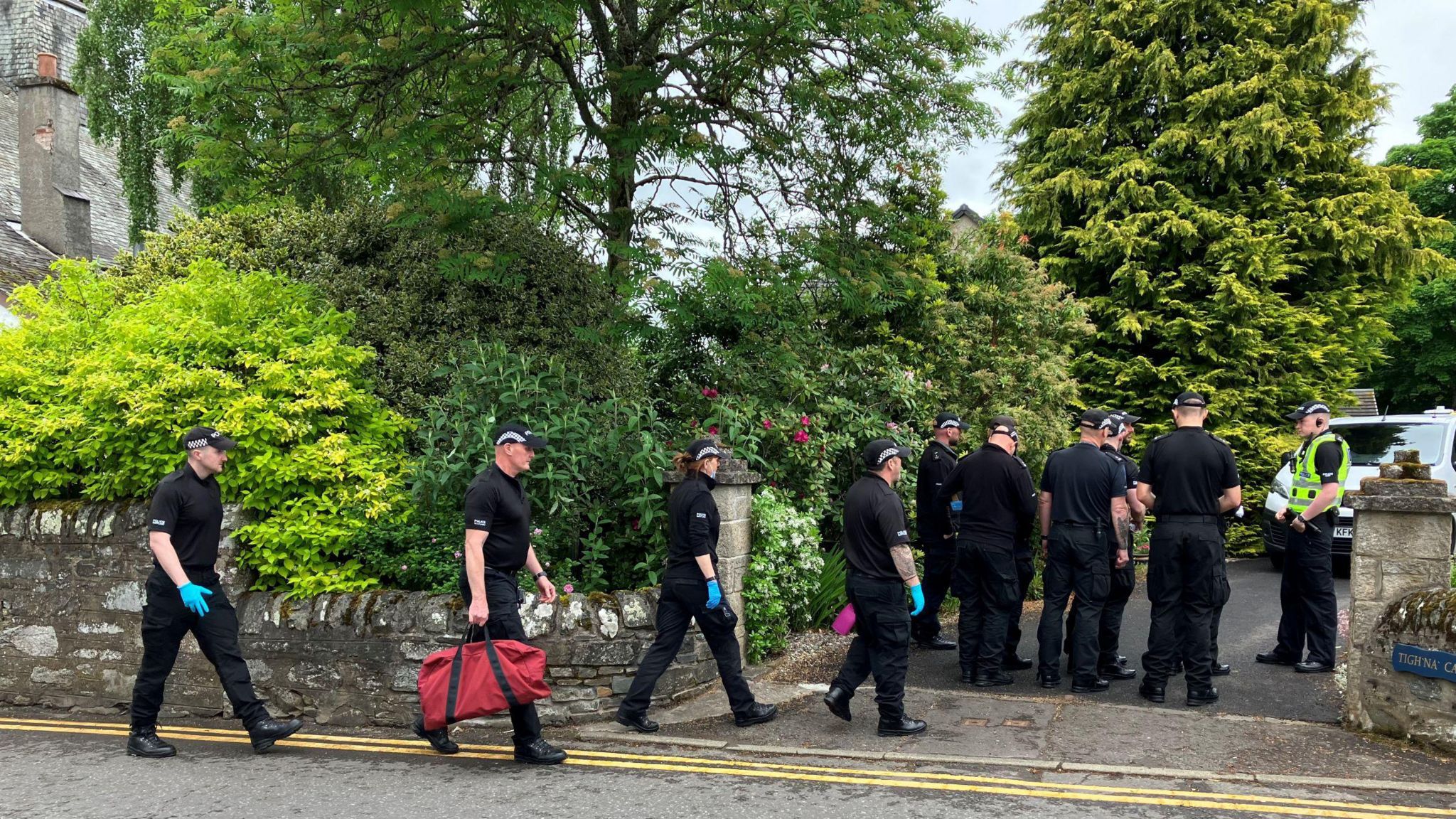 Police officers enter a home connected with the death of an Aberfeldy dog walker