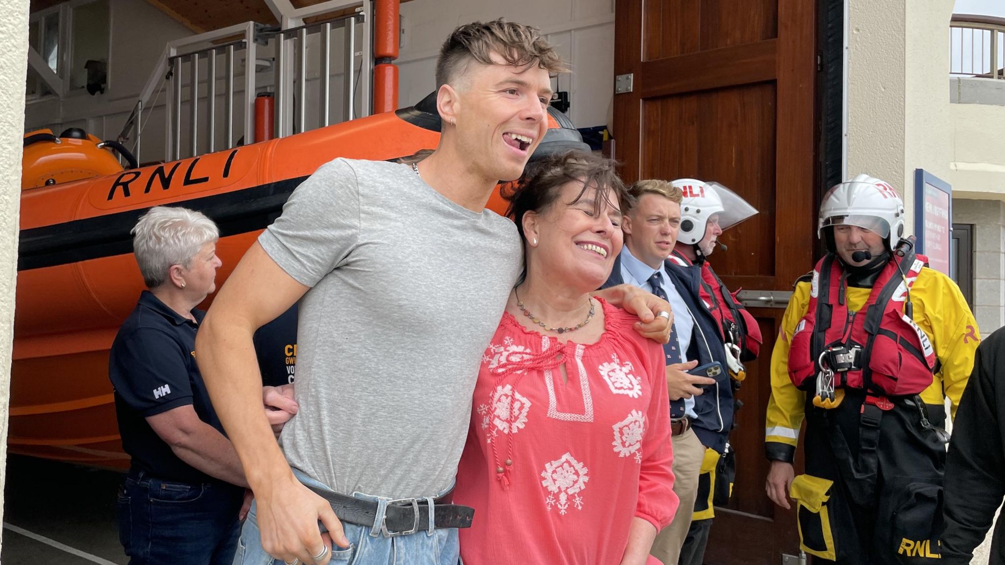 Ren Gill invites a fan to pose with him at the RNLI boat station in Beaumaris