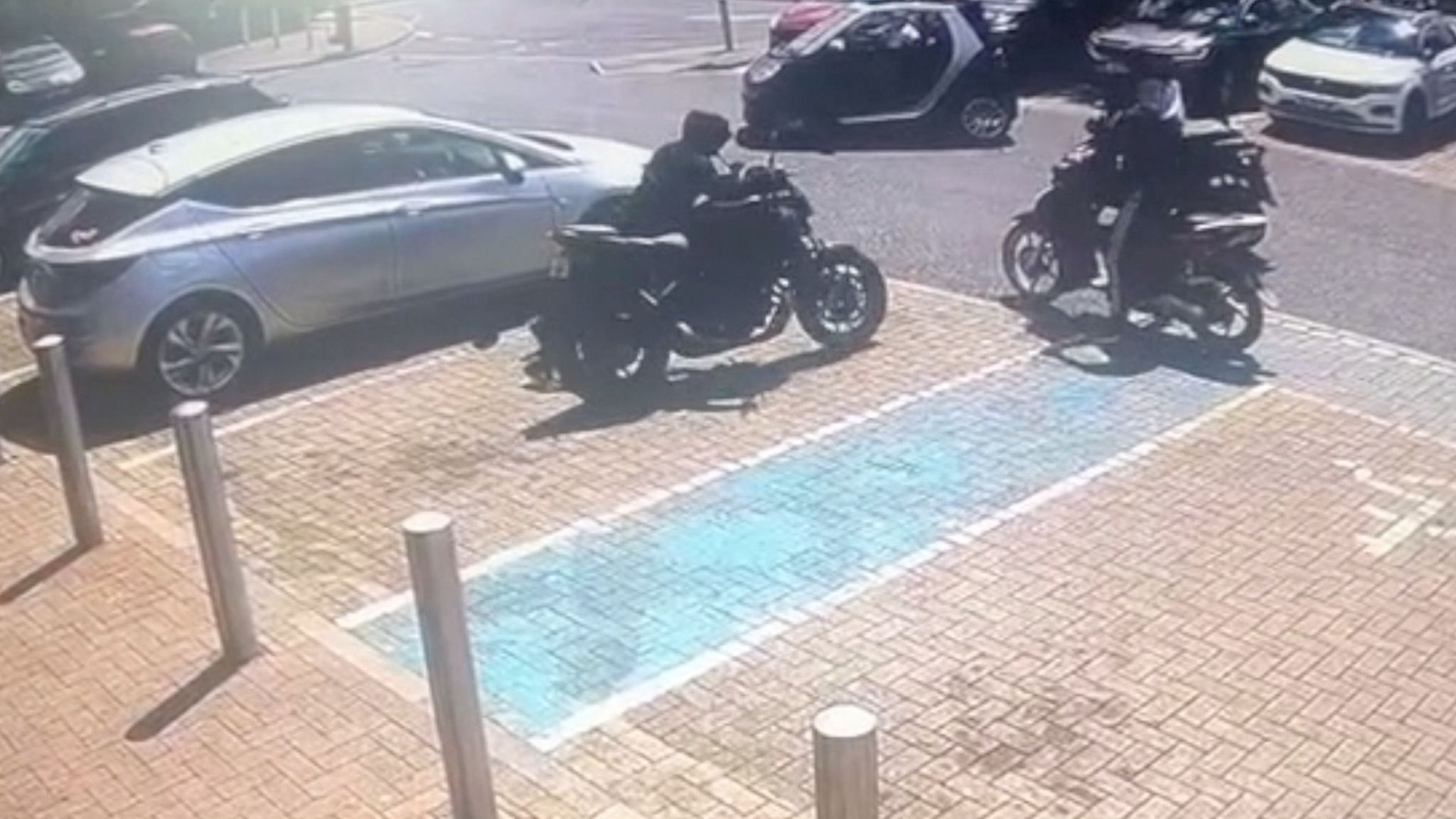 A car park with two motorbikes