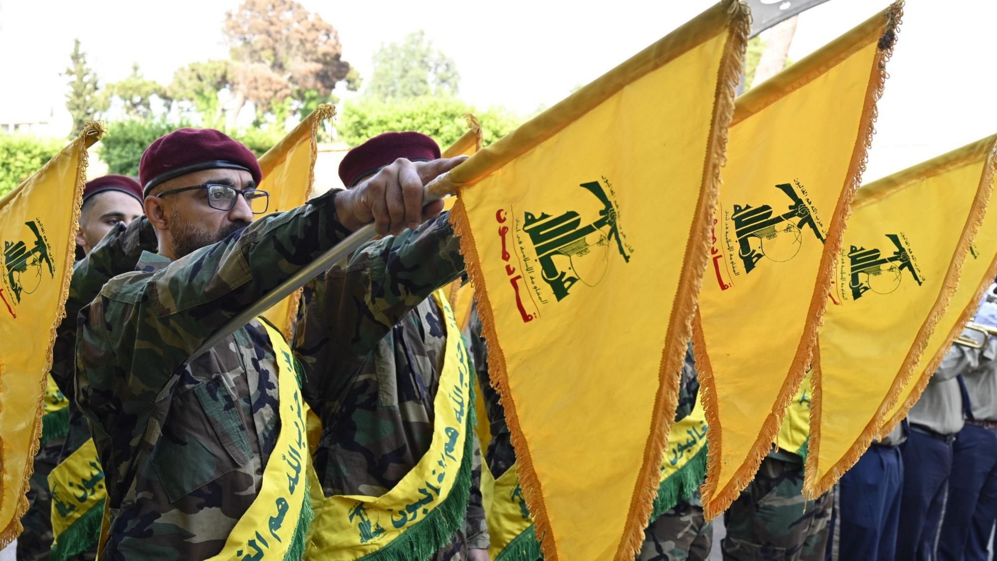 File photo showing Hezbollah members holding up the group's flags at a ceremony in Beirut, Lebanon (7 September 2024)