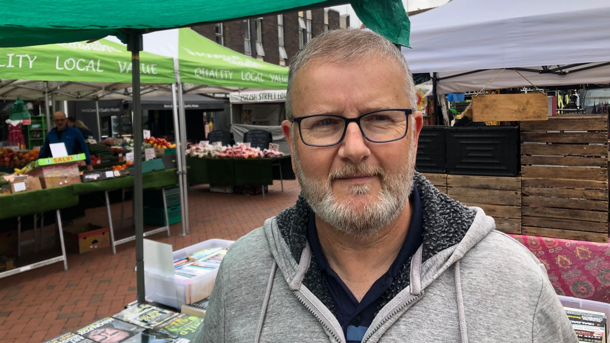 Andrew Sizer standing by a book market stall in Ely