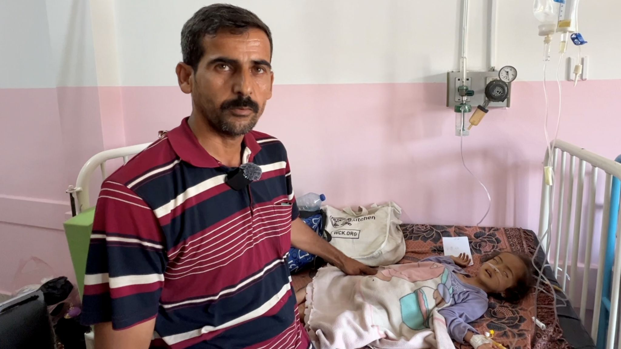 Father with child with drips on hospital bed