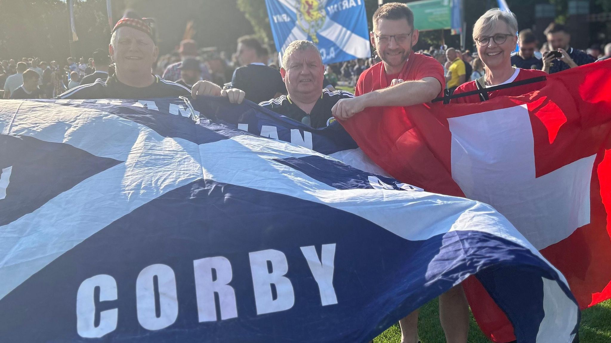 Two Scotland fans and two Swiss fans with flags