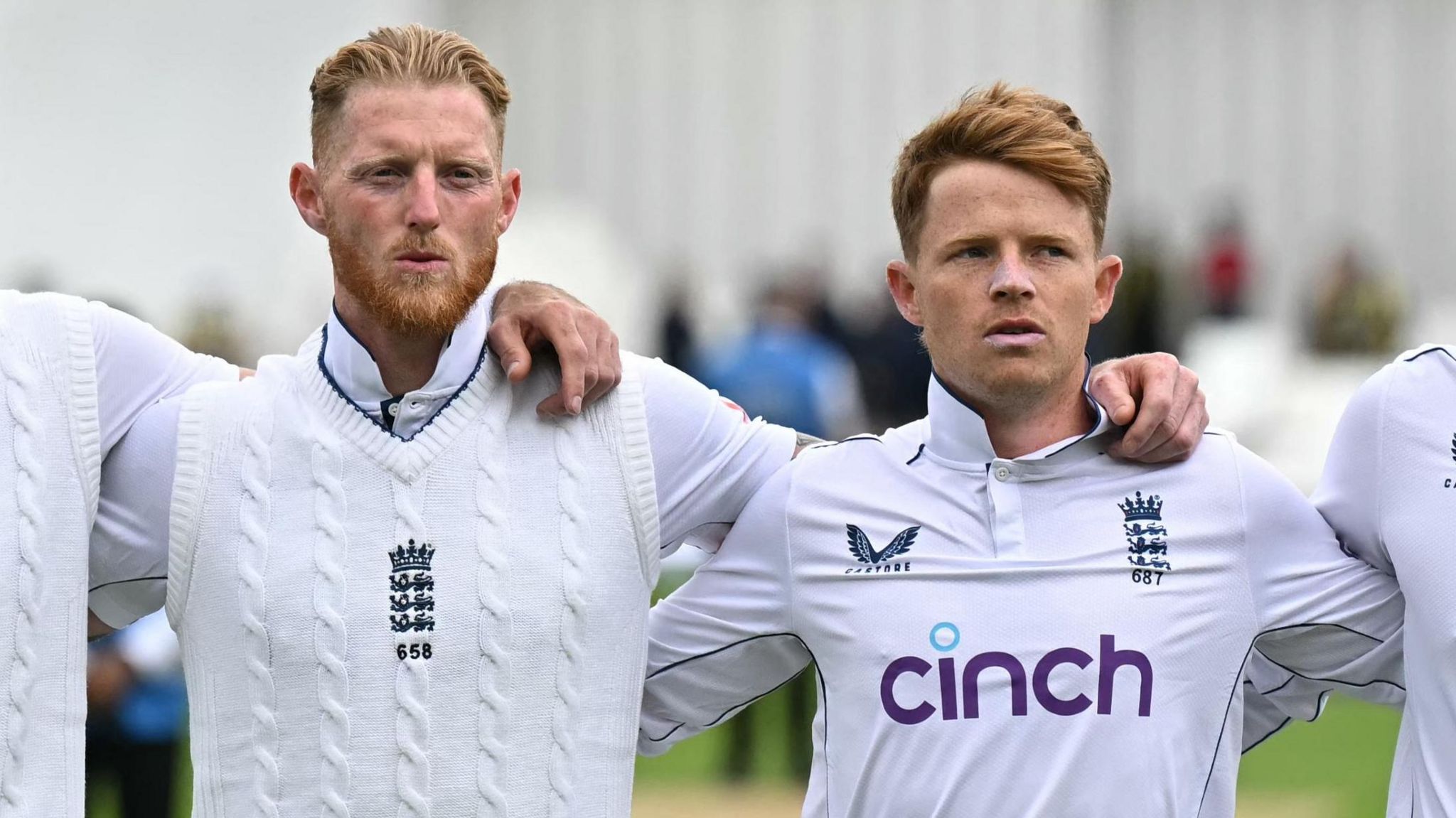 Ben Stokes and Ollie Pope stand arm in arm during the national anthem