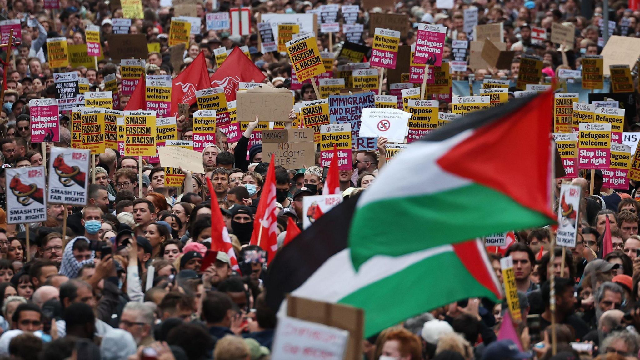 hundreds of people demonstrating with placards 