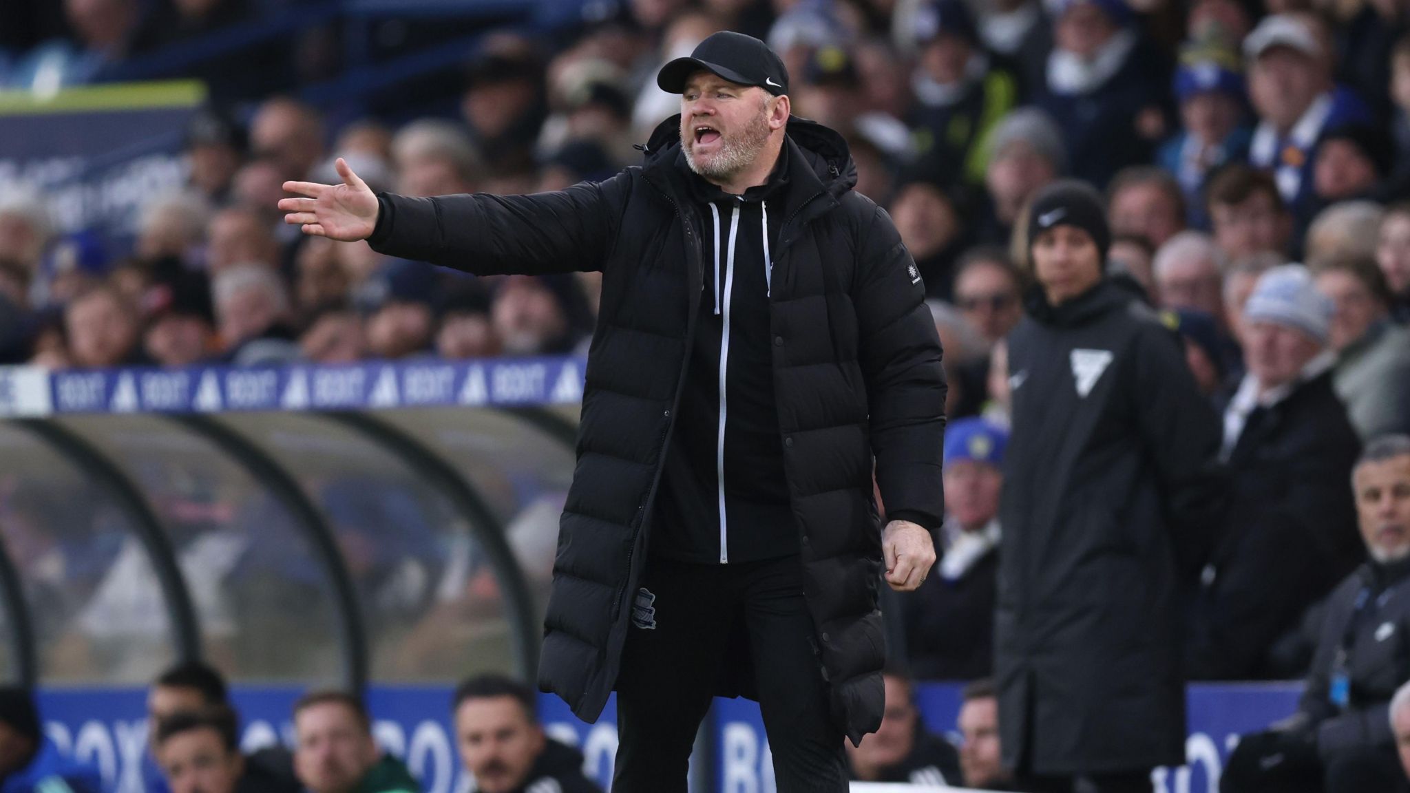 Wayne Rooney, while Birmingham manager, gesticulates with one arm out towards the pitch