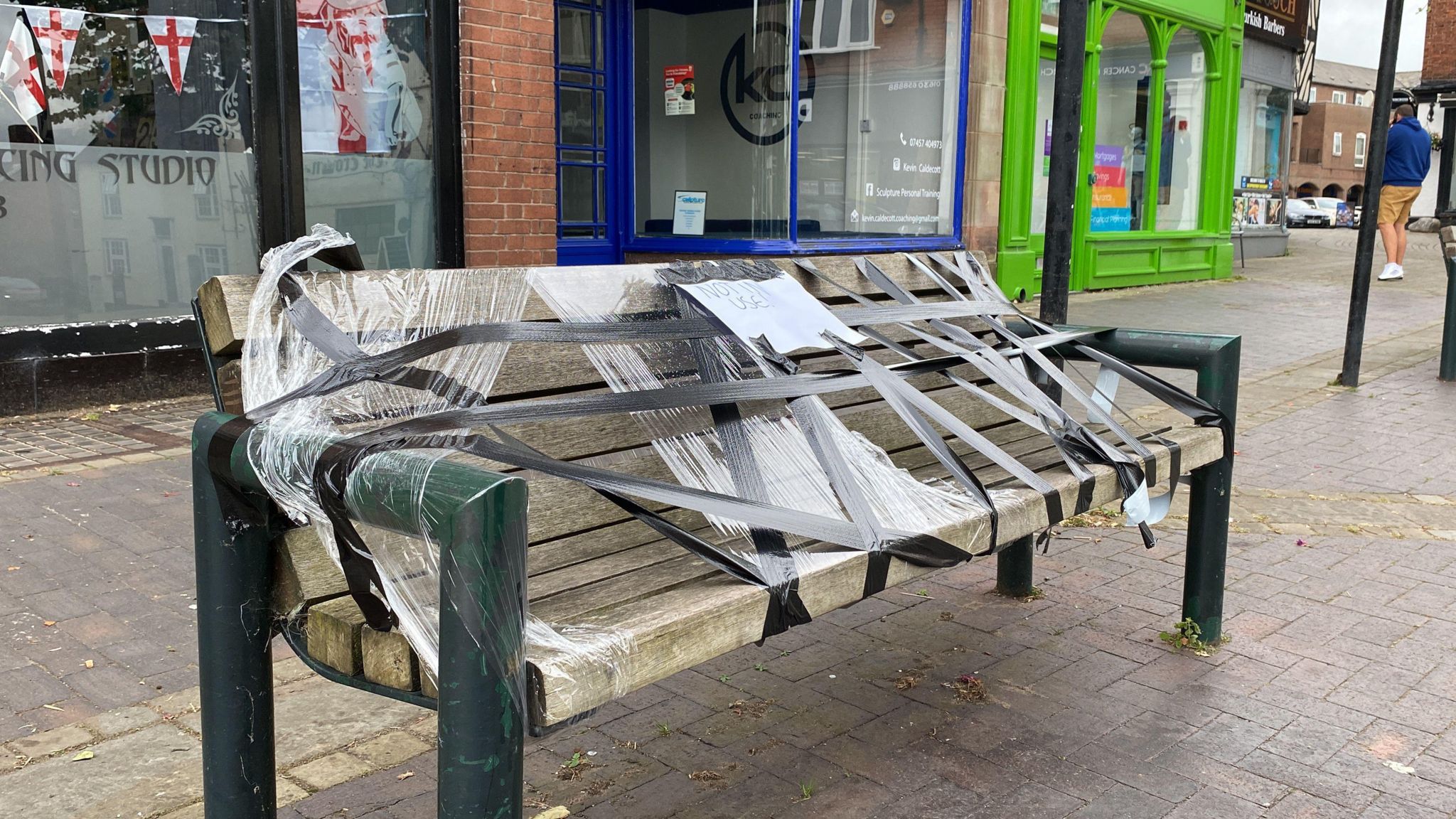 A bench with tape and clingfilm covering it