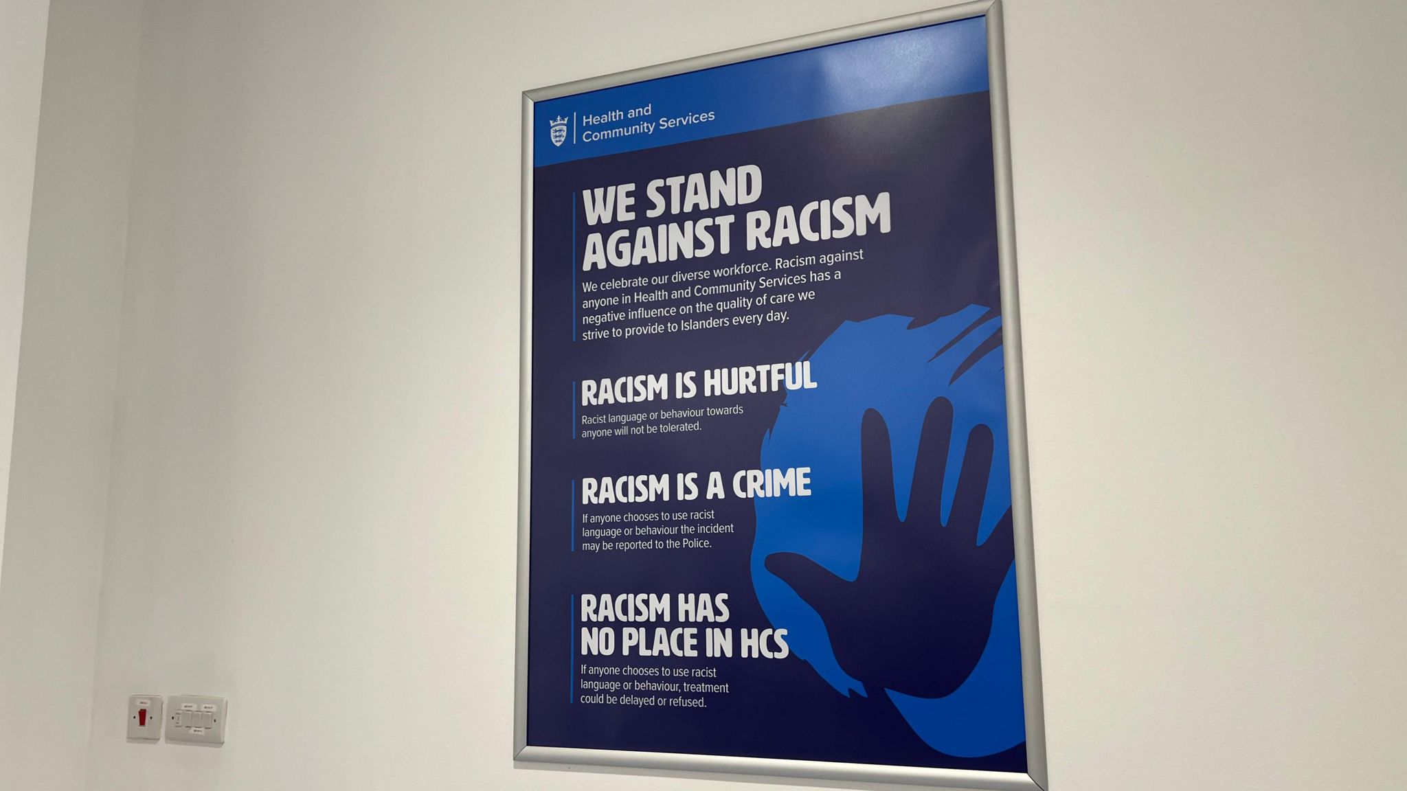 Anti-racism poster on a white wall in the hospital