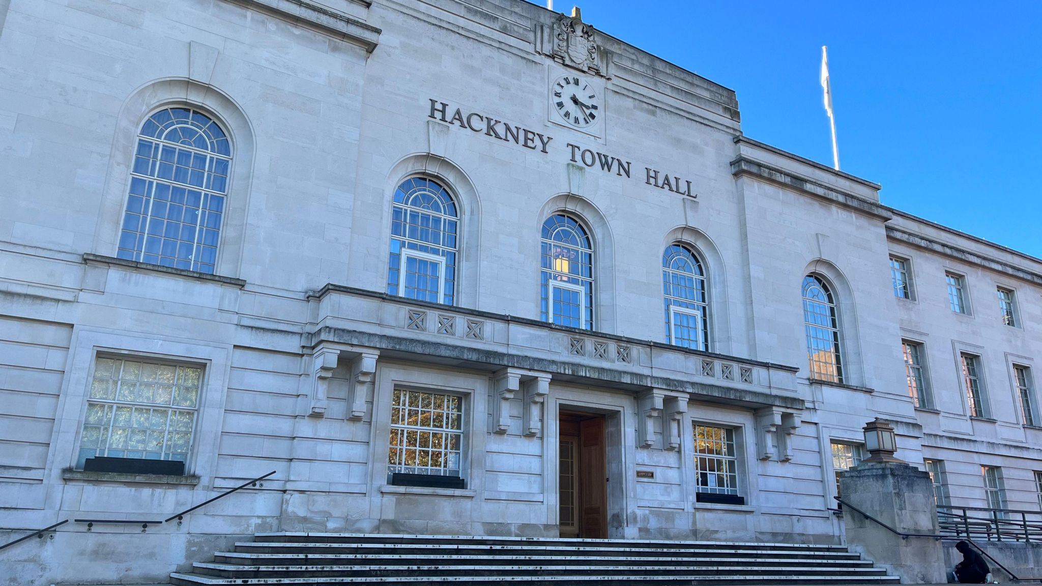 Exterior of Hackney Town Hall, a grey stone building with steps, taken in 2023