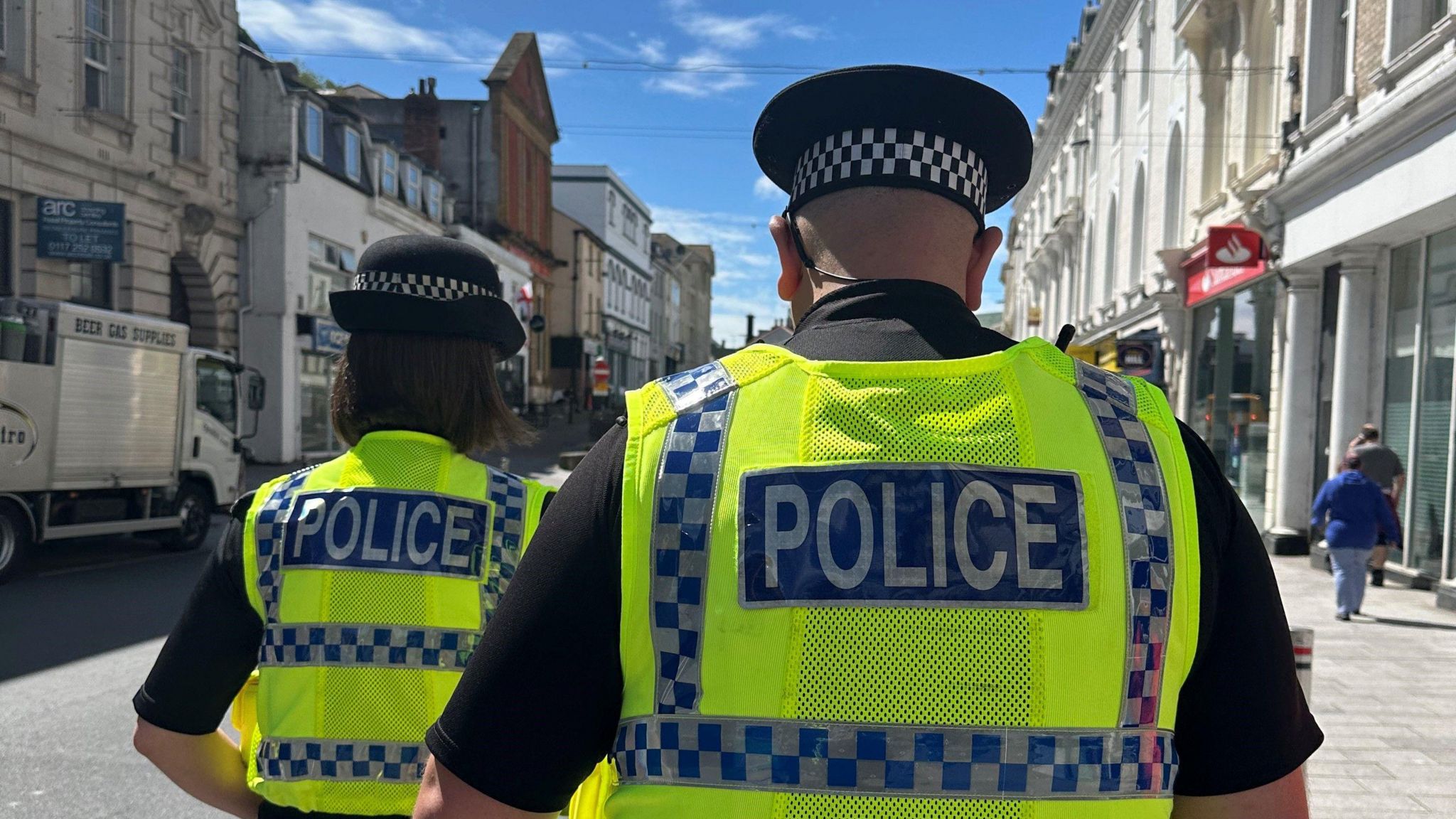 Two police officers walking along a Torquay pavement