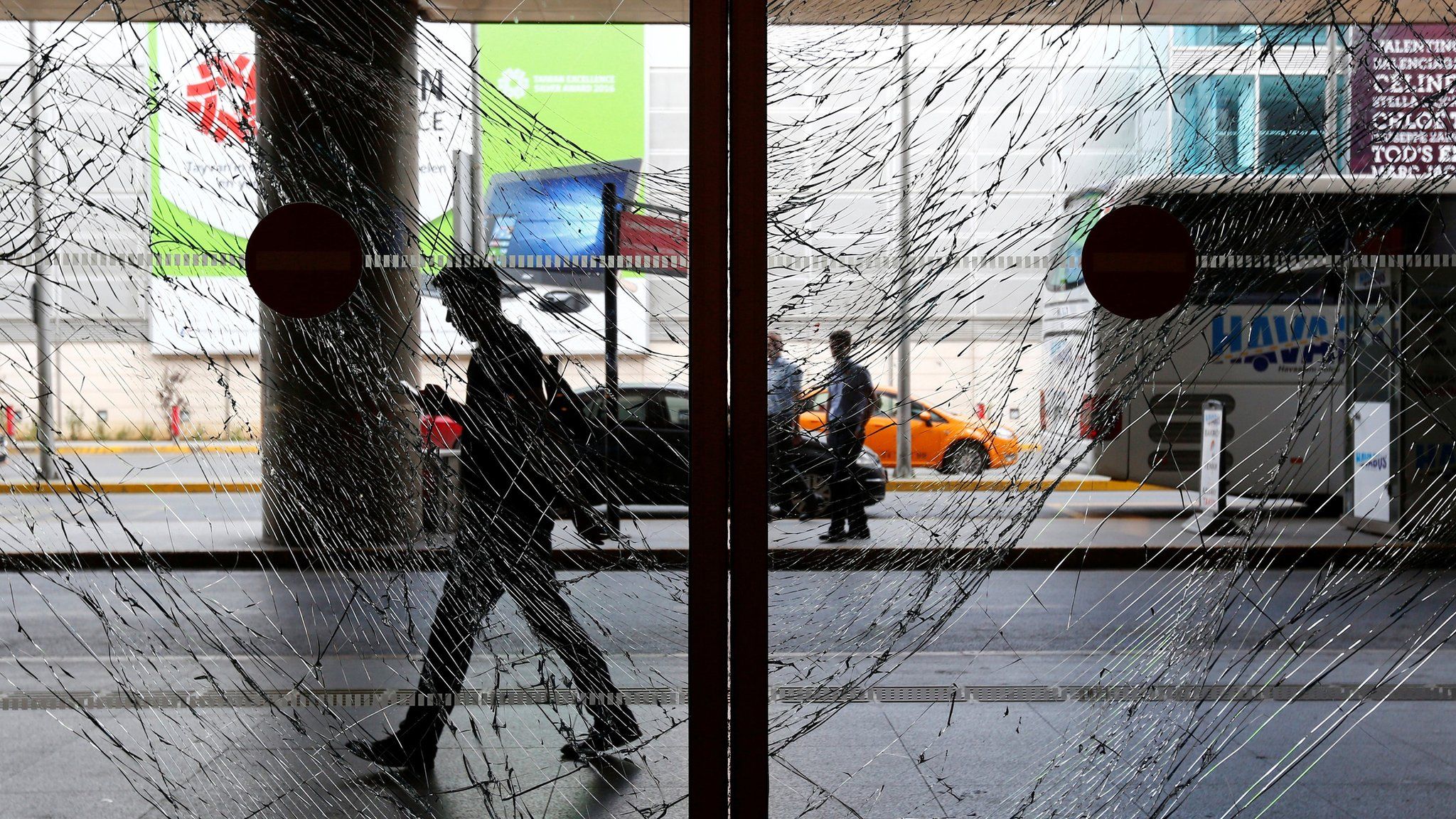 A man walks behind shattered glass at Turkey's largest airport in Istanbul following an attack, on 29 June