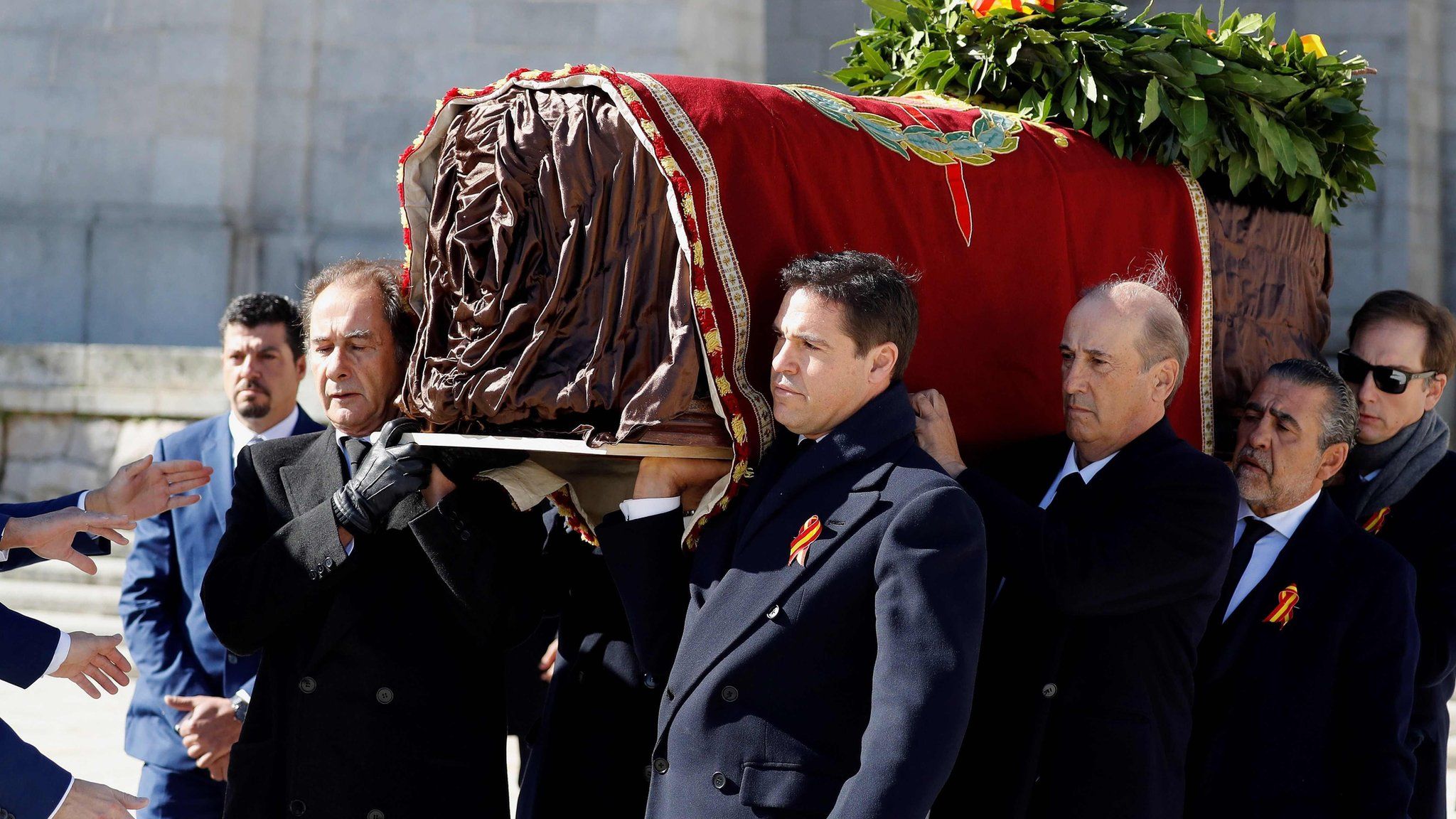 Relatives carry the draped coffin from the basilica to be loaded into a hearse