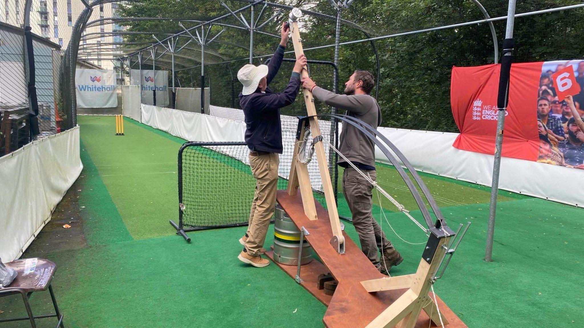 Prof Hugh Hunt and another man holding the bowling machine