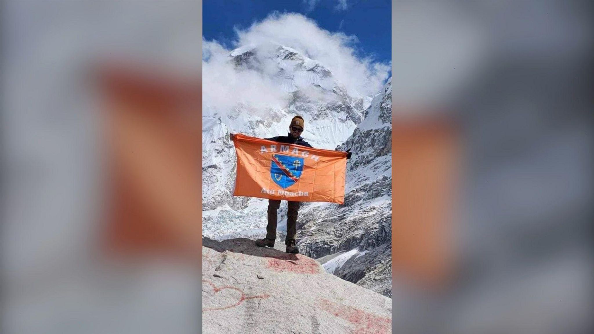 Seán Lavery holding an Armagh flag at Mount Everest base camp