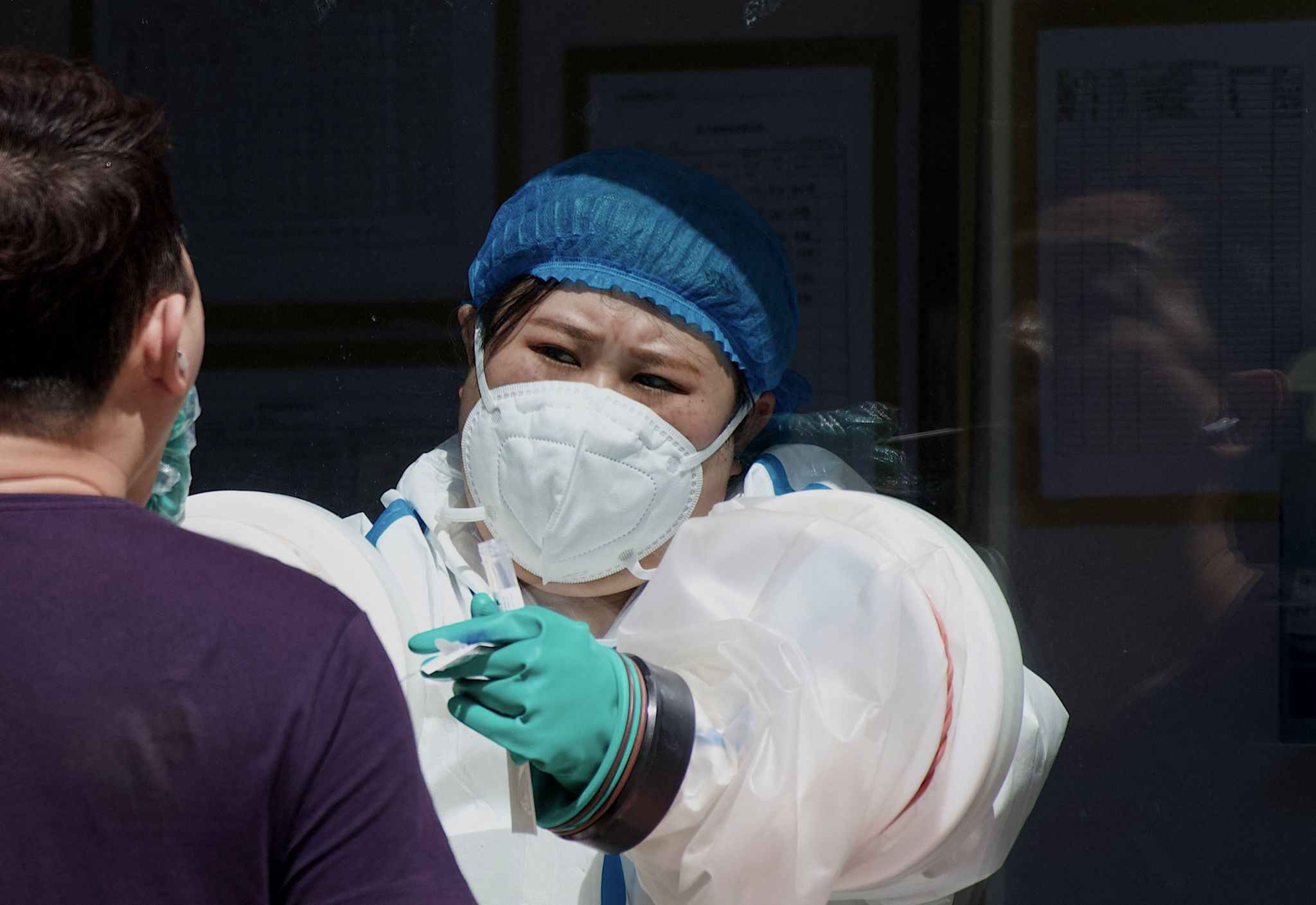 A health worker takes a swab sample from a man to be tested for the Covid-19 coronavirus at a swab collection site in Beijing