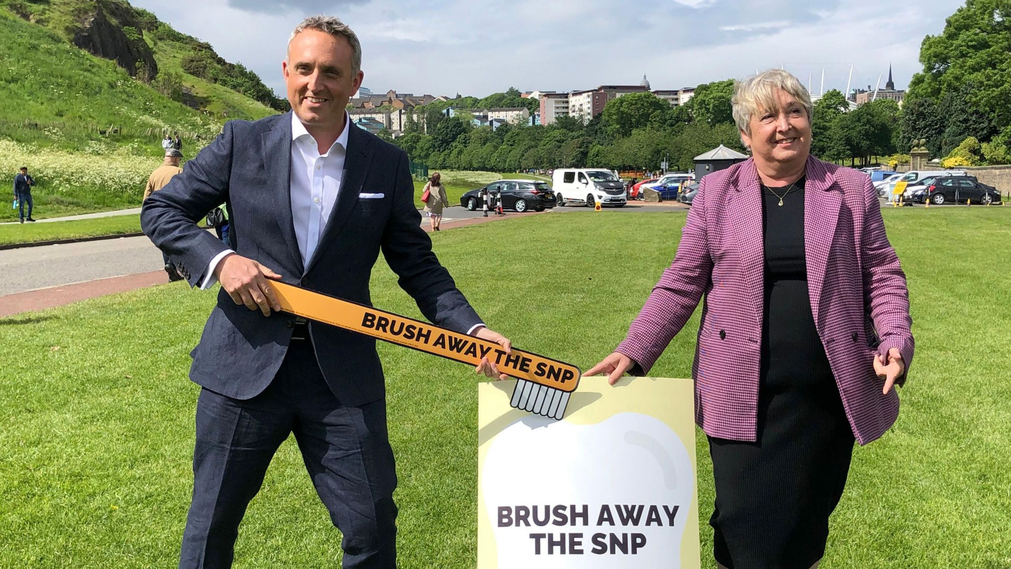 Alex-Cole Hamilton holding a big toothbrush with "brush away the SNP" on it