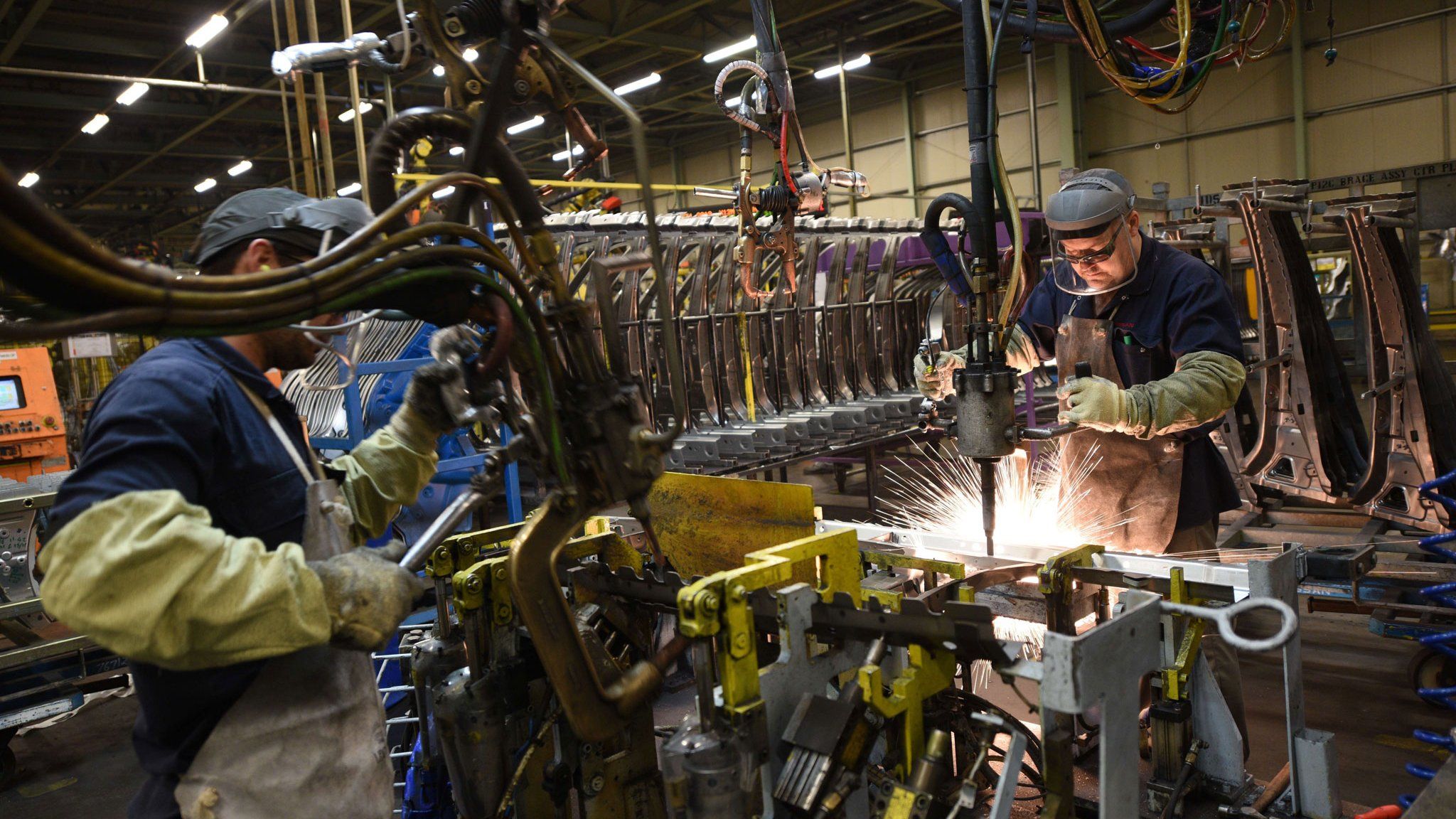 Two workers weld vehicle panels in Nissan's Sunderland factory in north east England, 12 Nov 2014