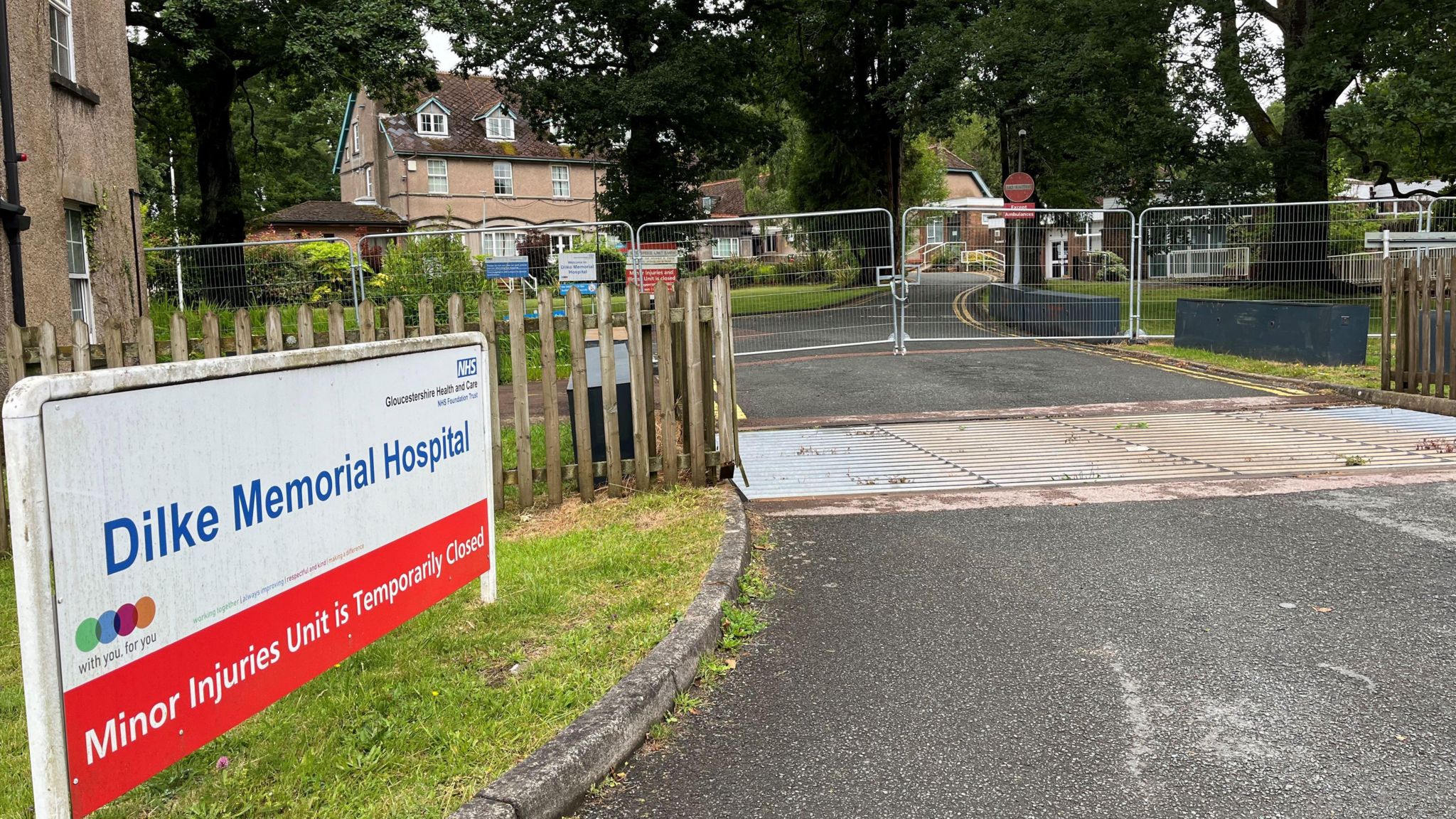 The Dilke Memorial Hospital building with a metal gate outside and sign saying it is temporarily closed