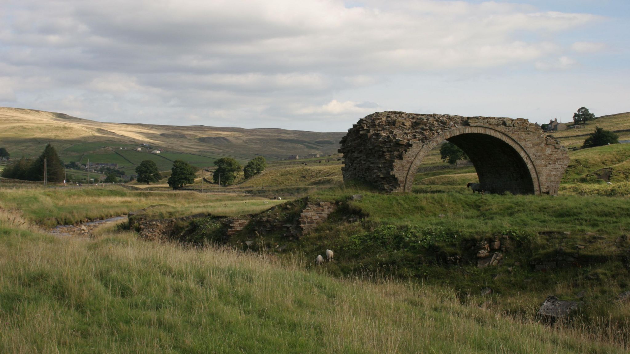 A single archway in a wide empty moorland landscape