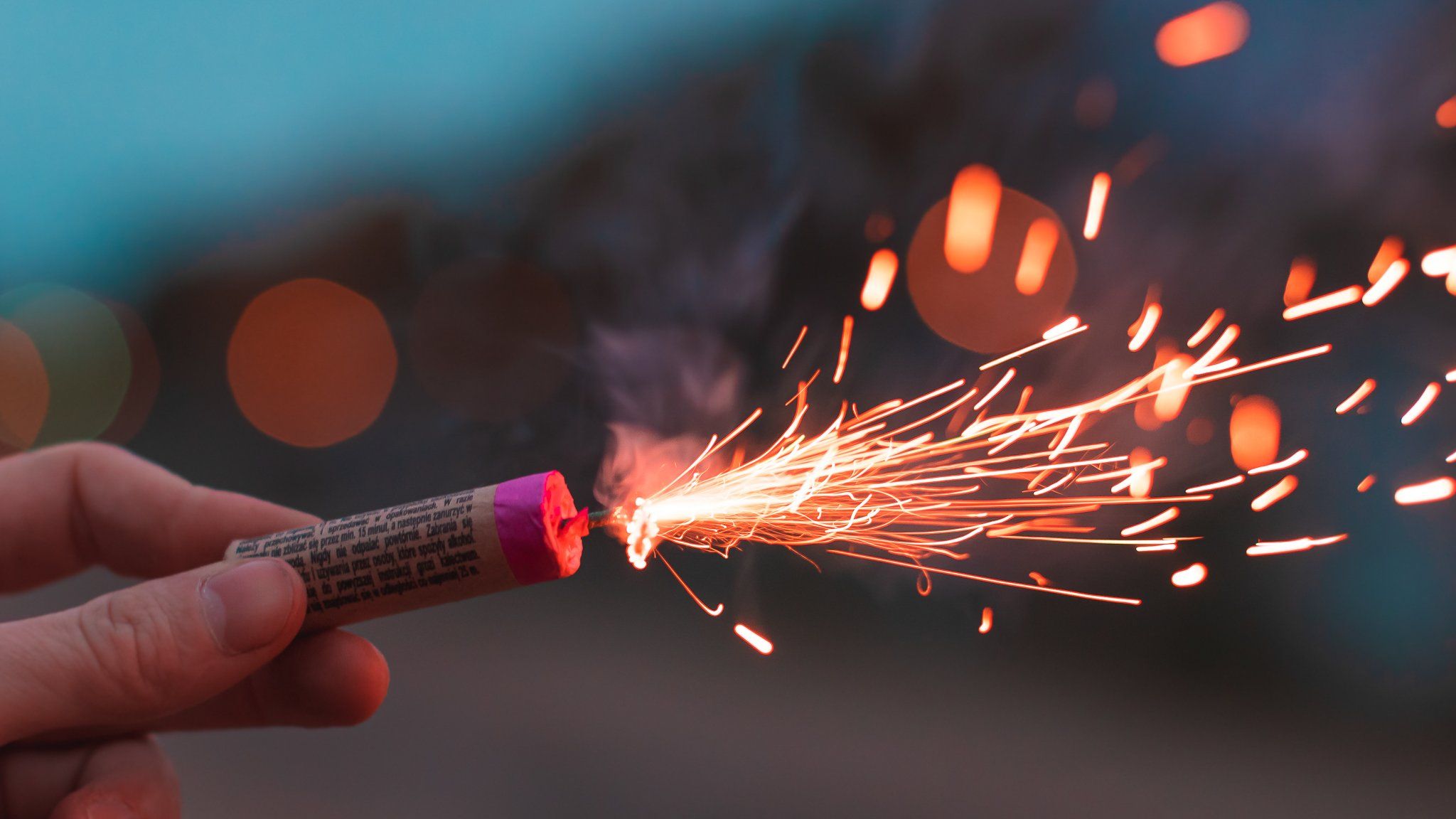 Hand holding a lit firework