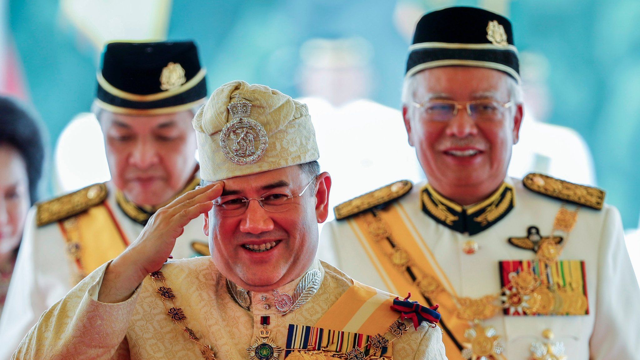 Sultan Muhammad V, centre, salutes after his welcome ceremony as he walks with Malaysian Prime Minister Najib Razak, right, at the Parliament House in Kuala Lumpur, Malaysia, 13 December 2016.