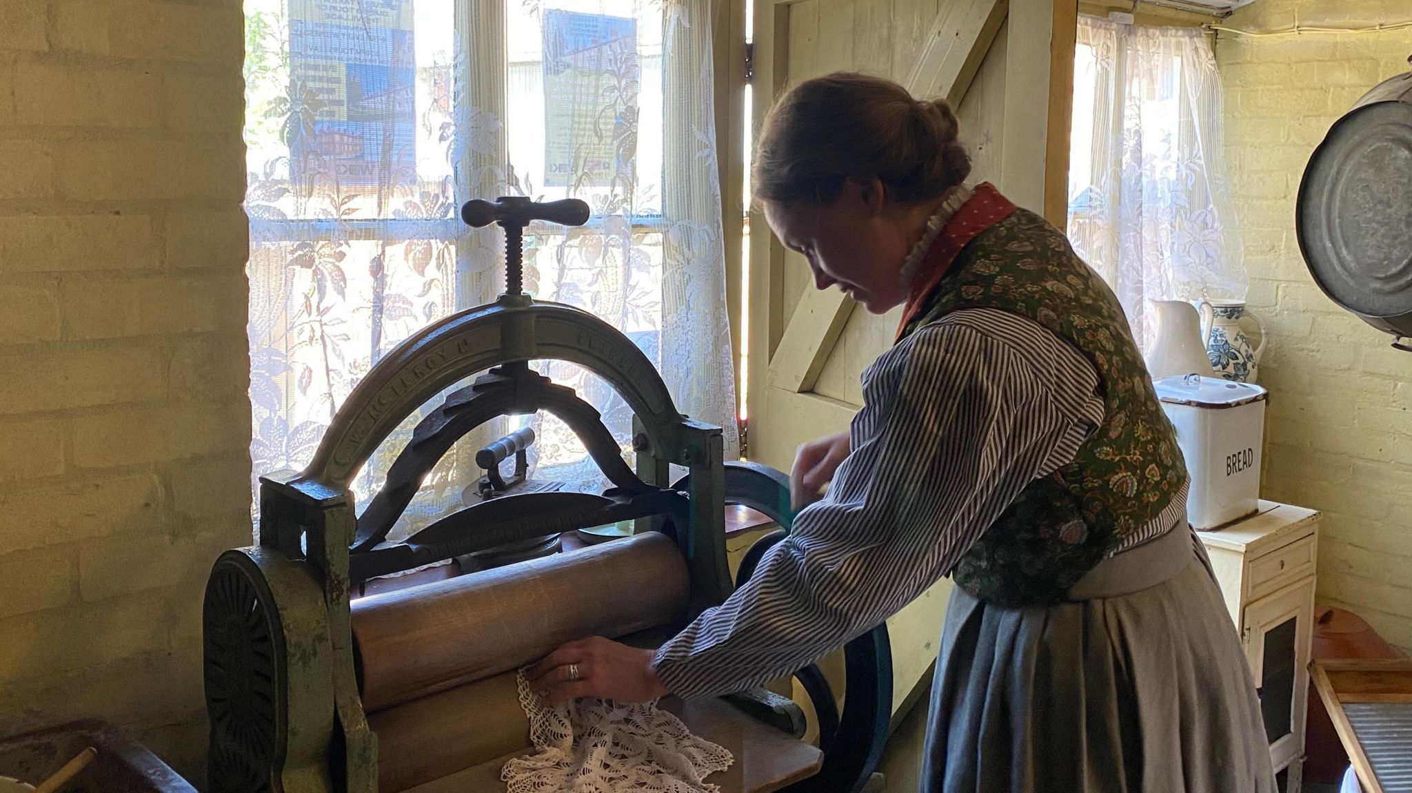 The actor pressing a piece of fabric in one of the cottages.