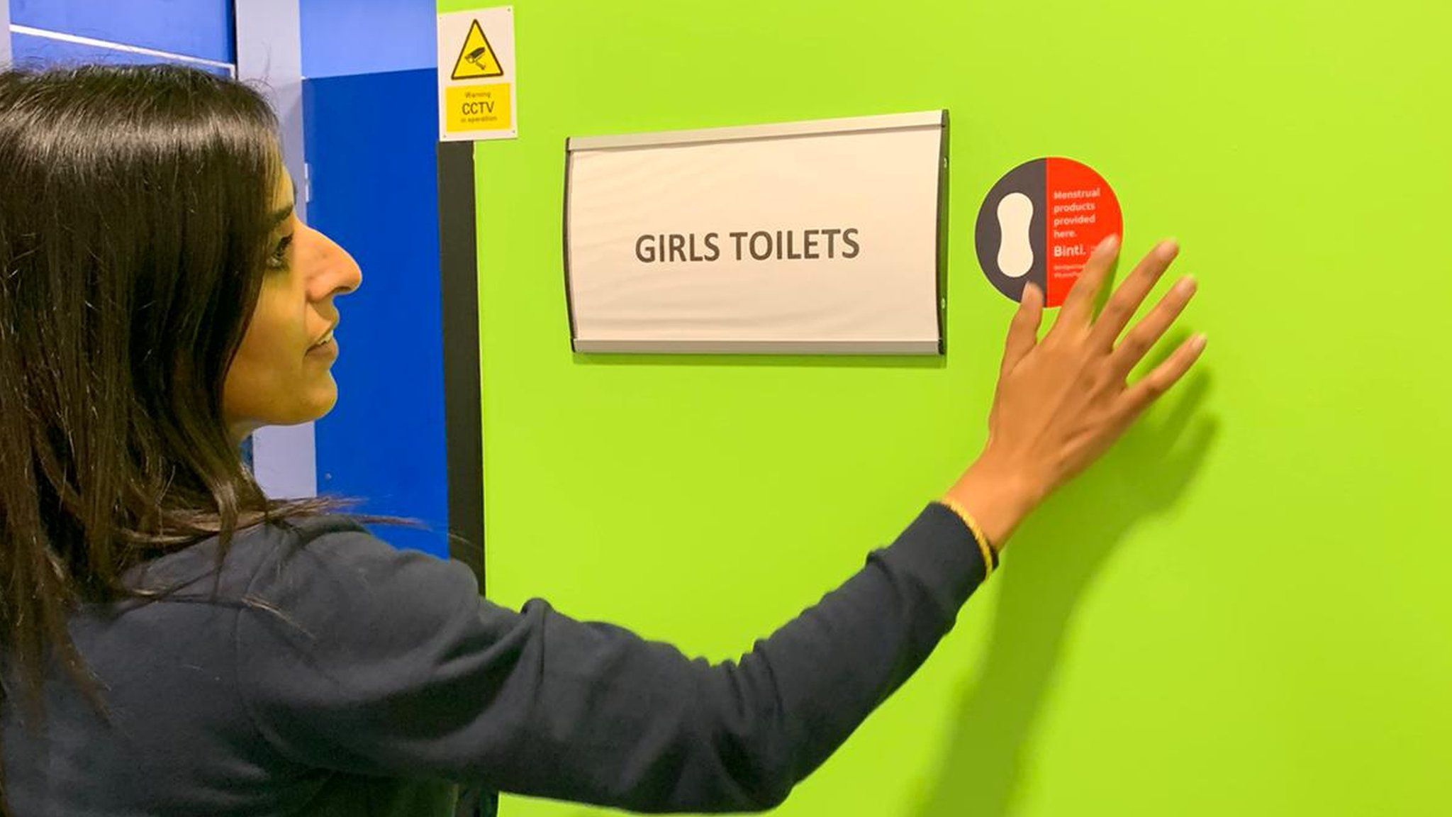 School teacher putting sign up outside toilets