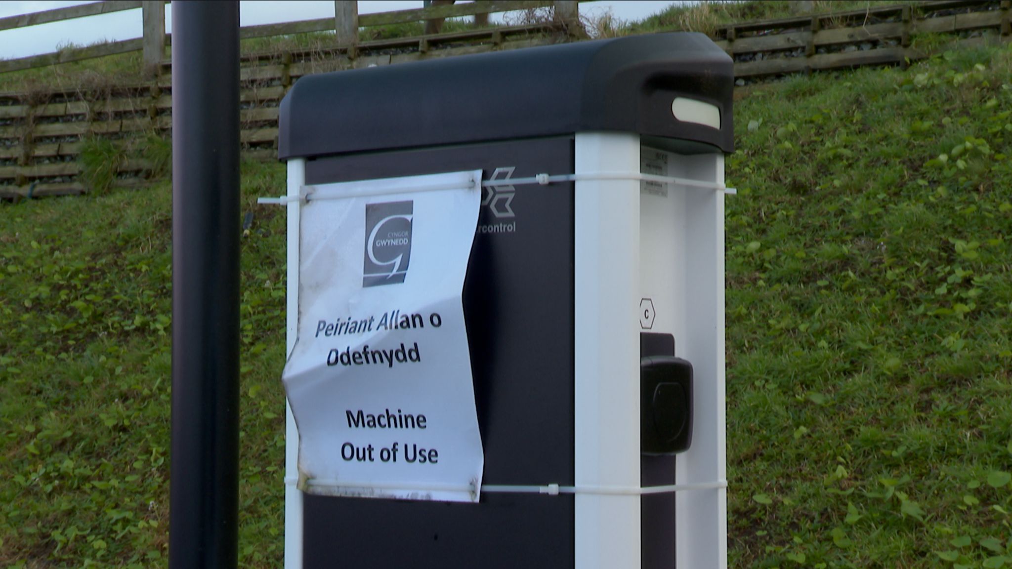 EV charge point with a machine out of use sign on it in Welsh and English 