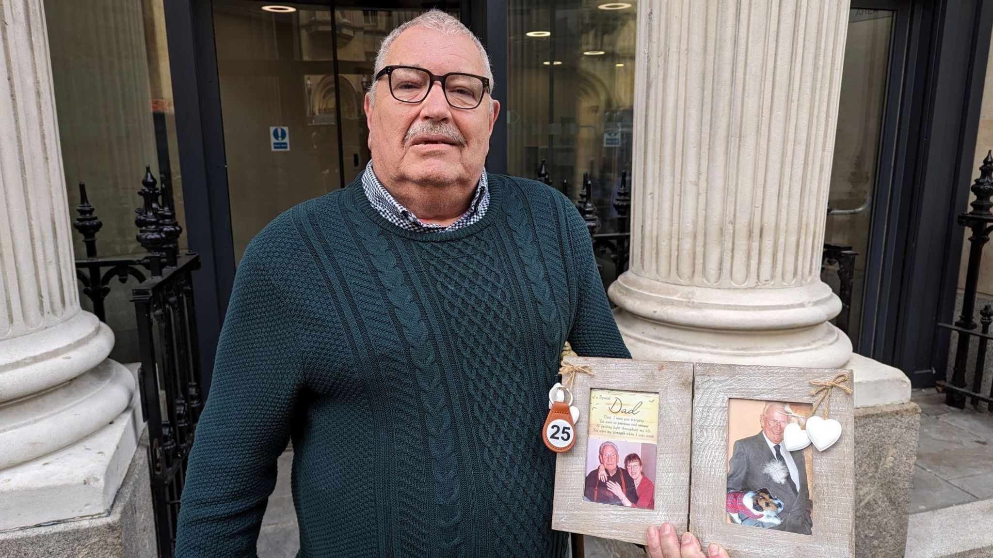 Kevin Burge outside court holding a picture of his father
