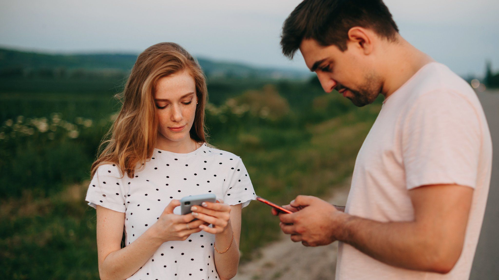 Man and woman looking at mobile phones