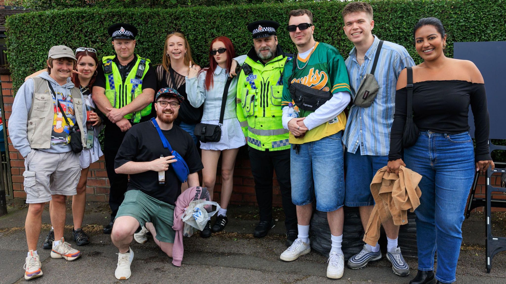 Two police officers pose with eight people attending Parklife festival in Manchester