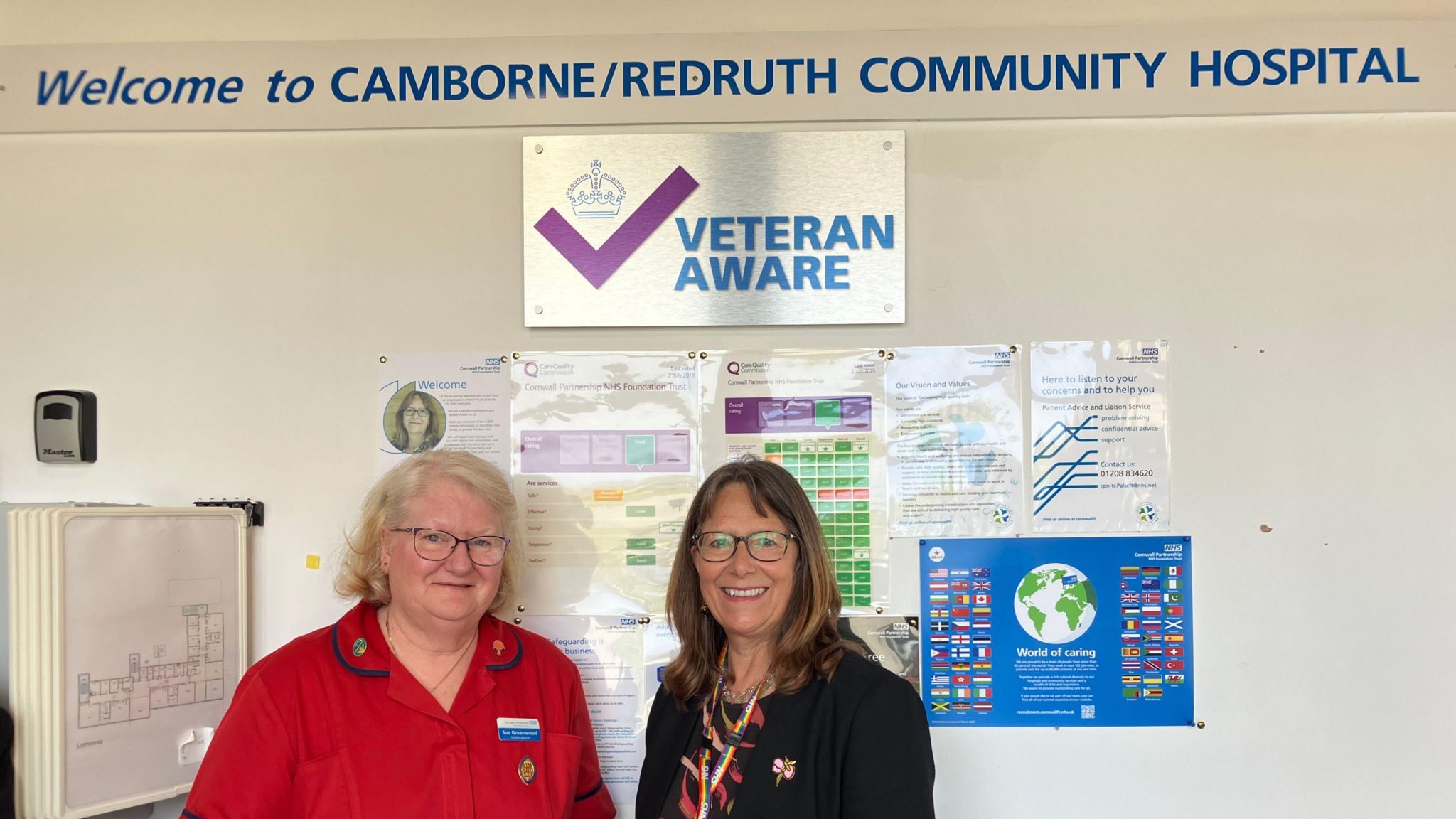 Sue Greenwood, Matron of Camborne Redruth Community Hospital and Debbie Richards, Chief Executive of Cornwall Partnership NHS Foundation Trust standing below the new Veteran Aware plaque