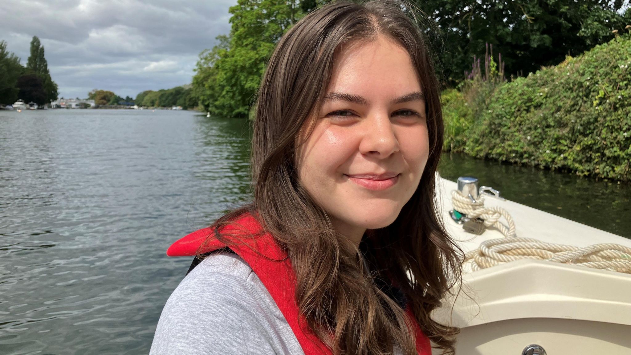 Izzy Wittrock sitting on a boat smiling at the camera